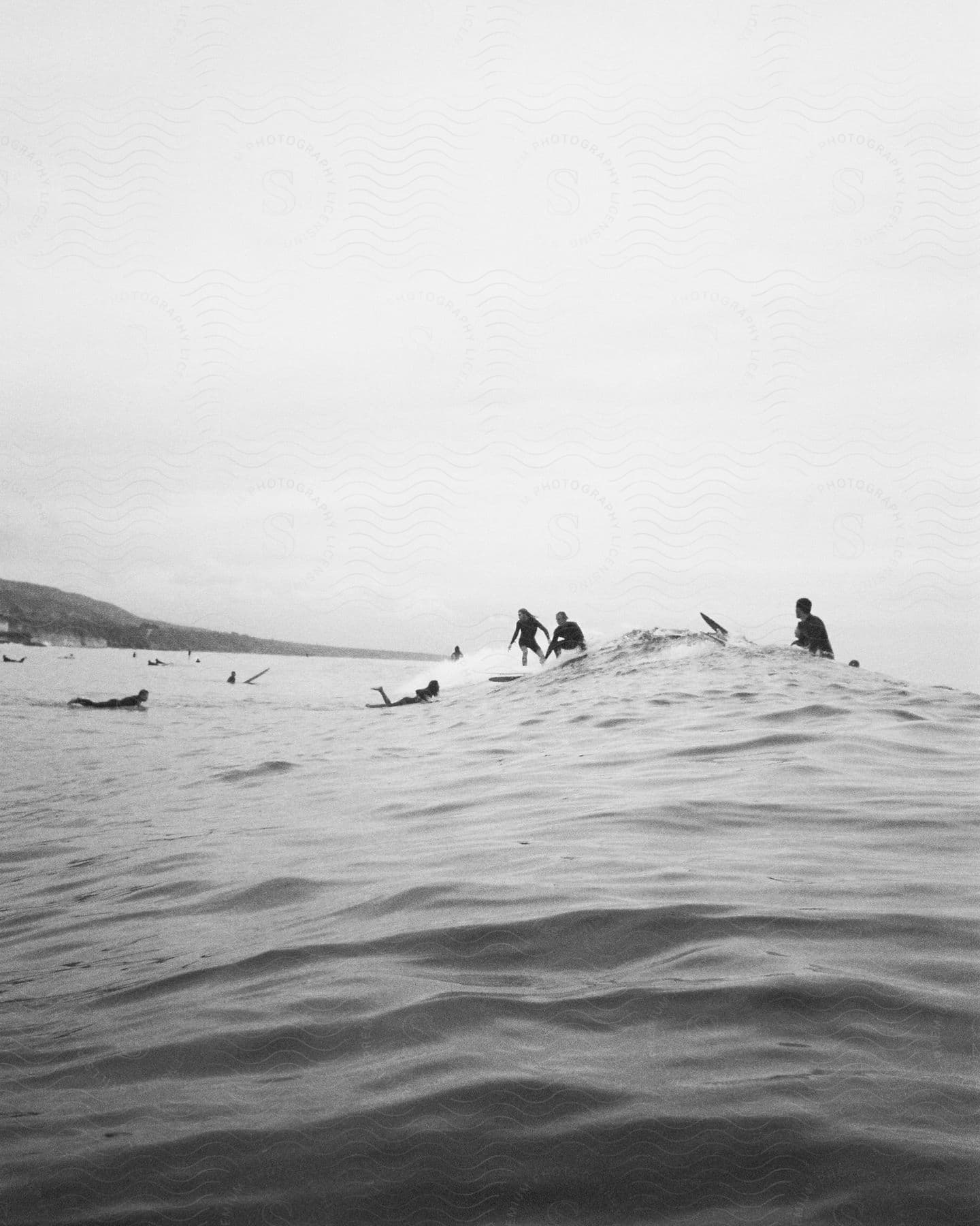 People in the water off the coast on surfboards