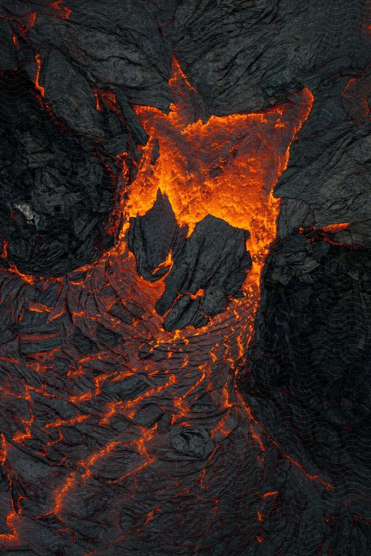 Hot lava glows as it flows from an erupting volcano