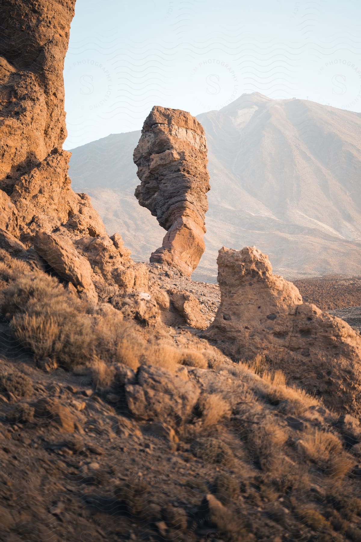 Rock formations on a mountainside and mountains in the distance