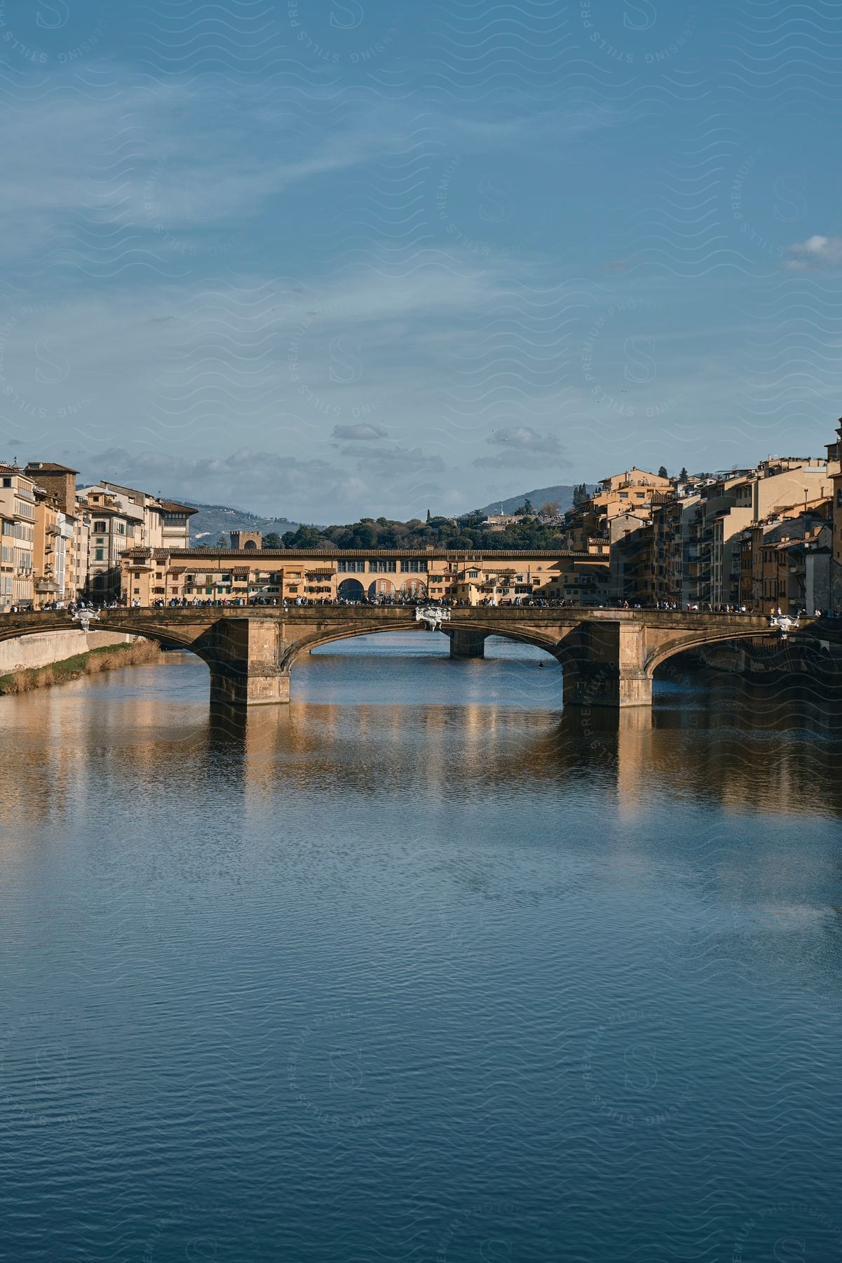 The crowded concrete bridge connects two cities during the daytime.