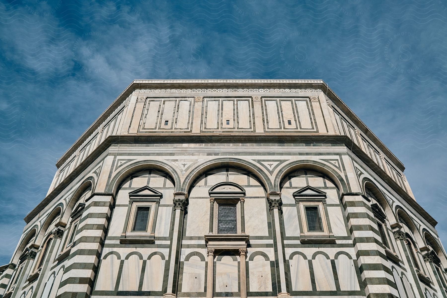 A large historic building with intricate architectural details, standing out against a pale blue sky.