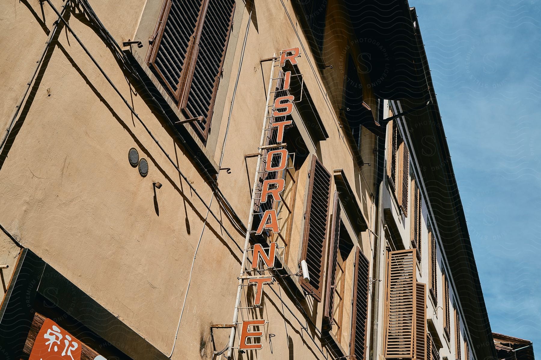 a building with a sign that says ristorante on it's side widows with shudders around it