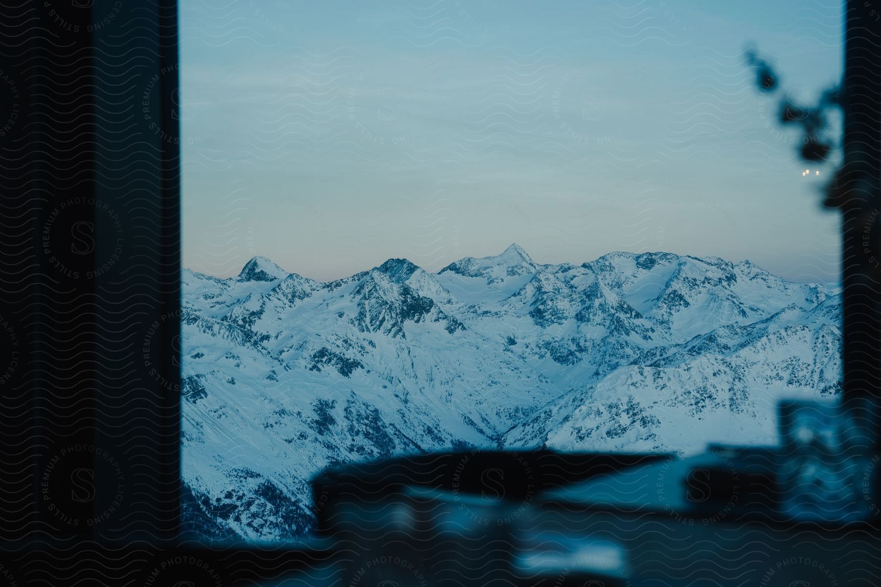 View through a window of a snow covered mountain range