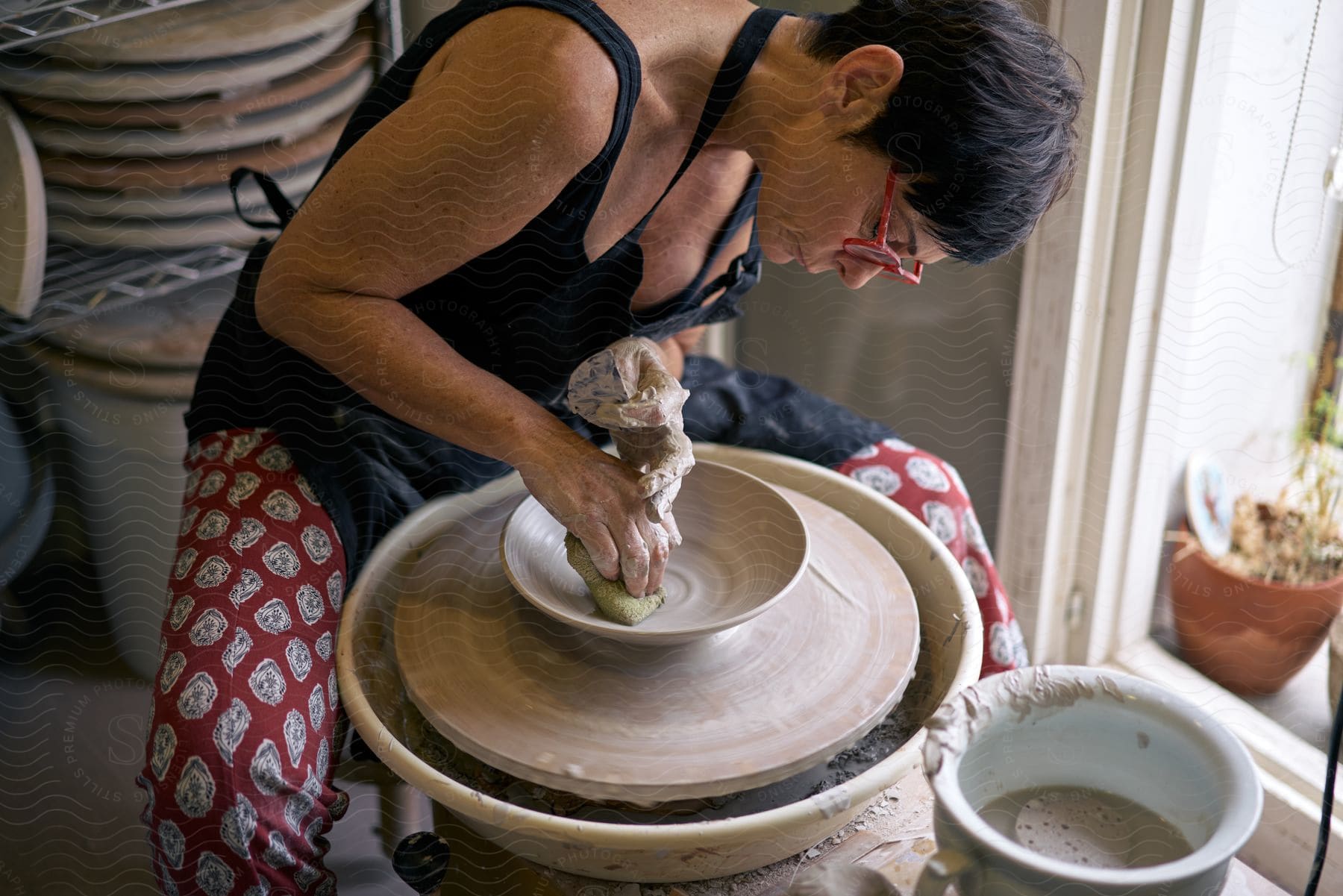 Man working with clay making a bowl on a pottery wheel