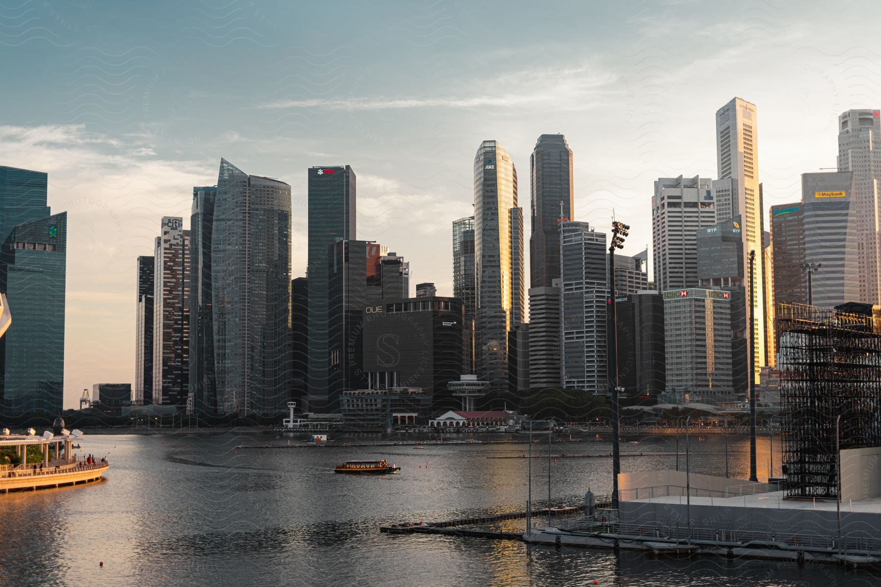 Singapore's bustling skyline rises from the waterfront, with boats bobbing on the harbor and people strolling along the port