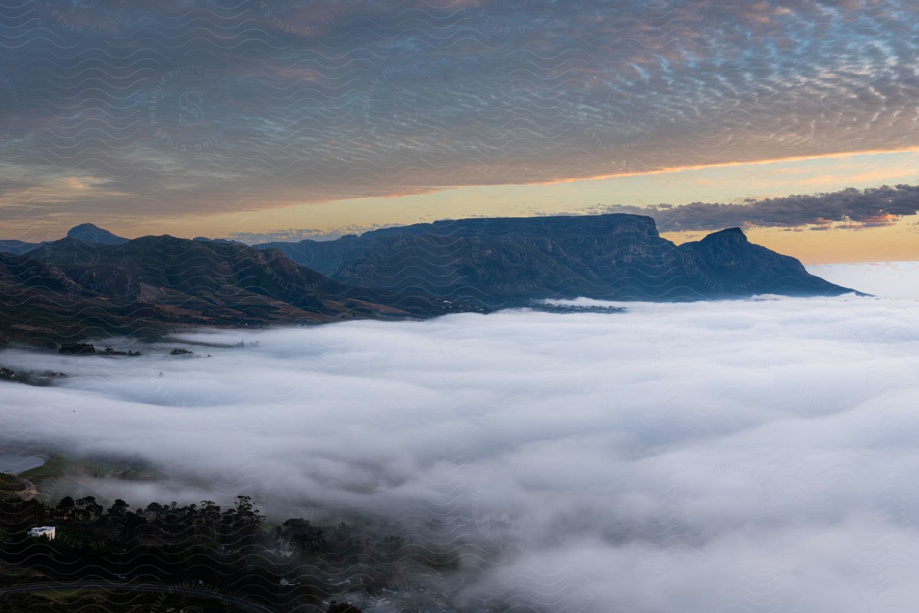 A lot of fog is covering the ground below mountains.