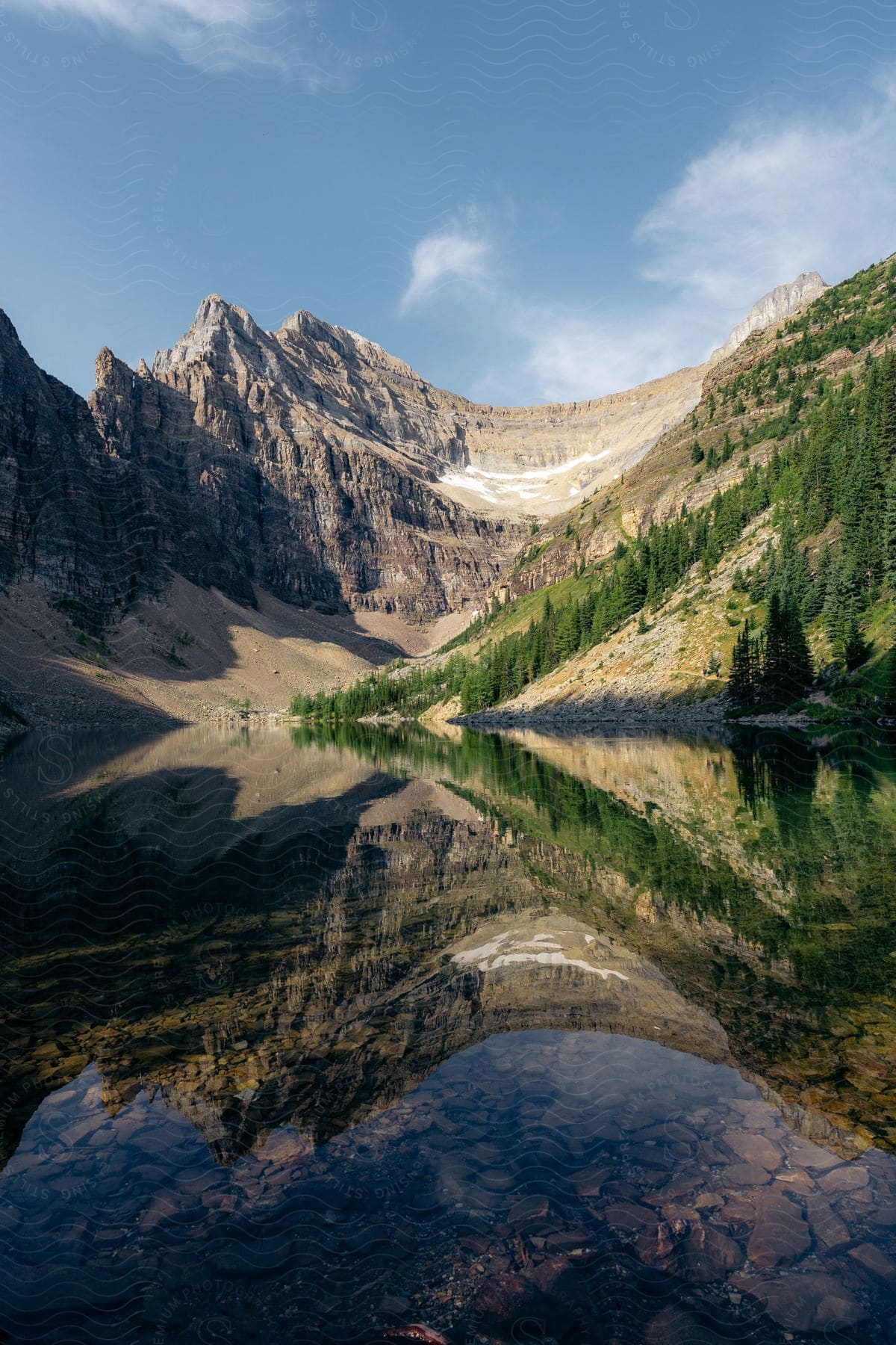 A calm lake reflects a majestic mountain range in Banff National Park, Canada.