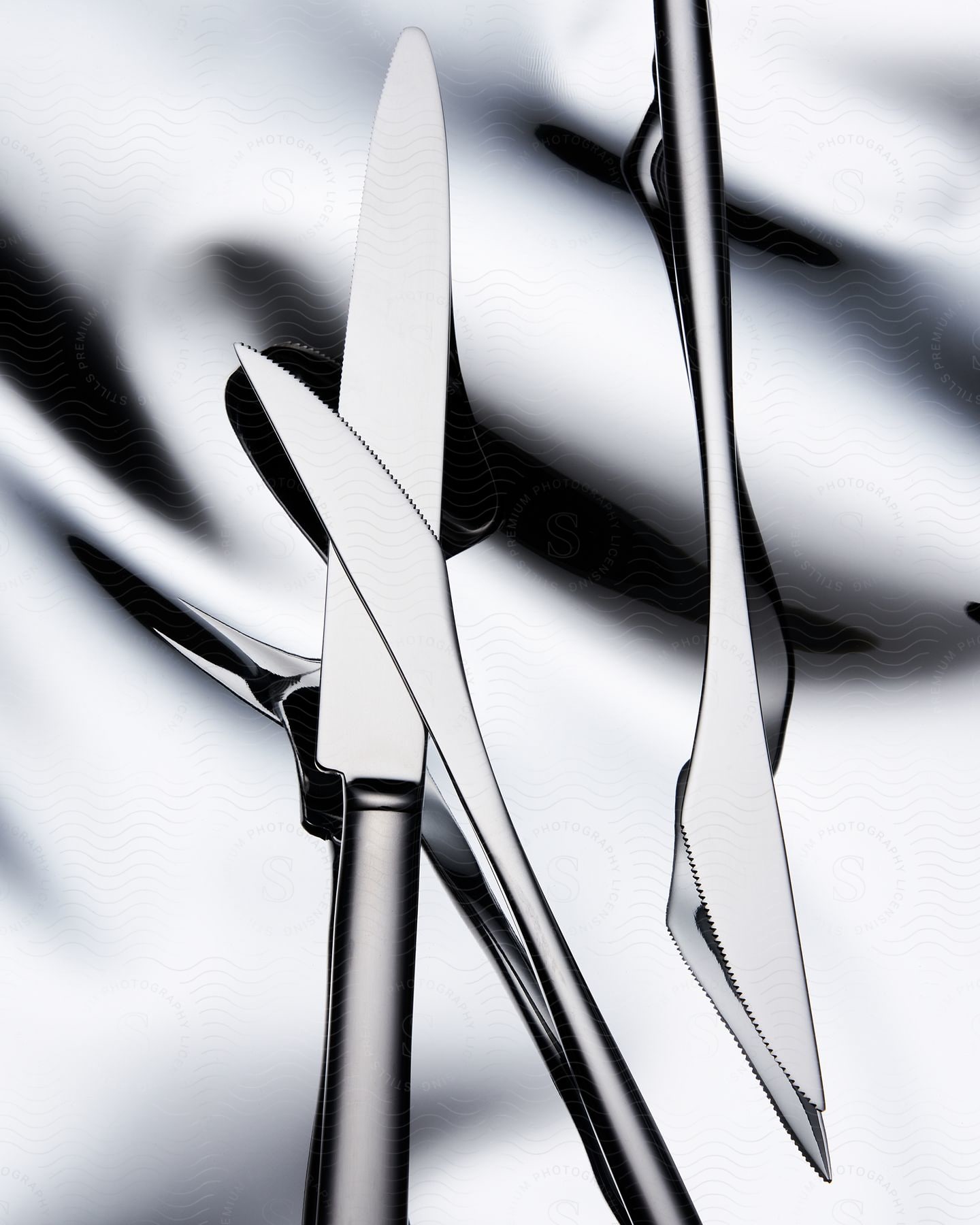 Stainless steel knives superimposed against a silver background