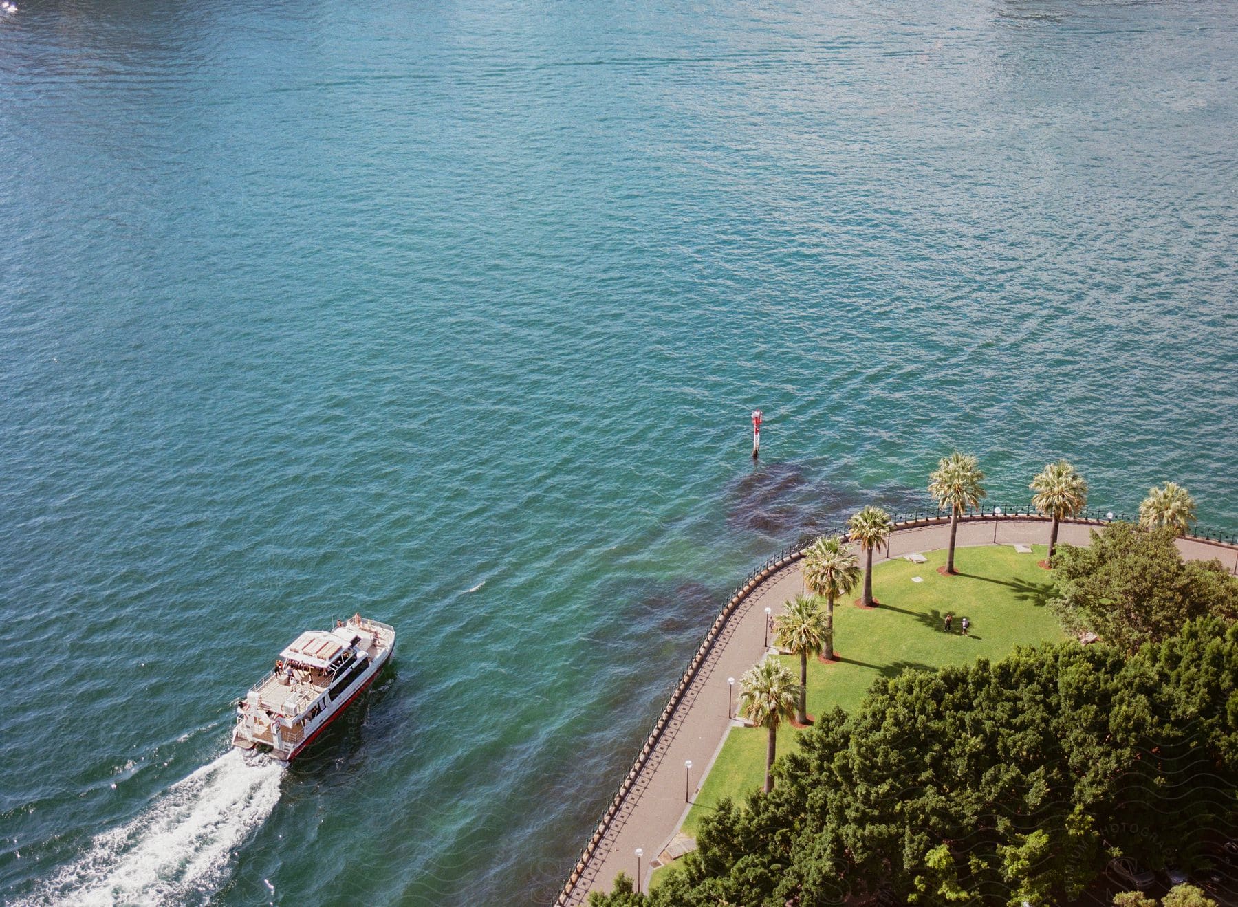 Aerial panorama of a seaside park with tourist boat passing alongside