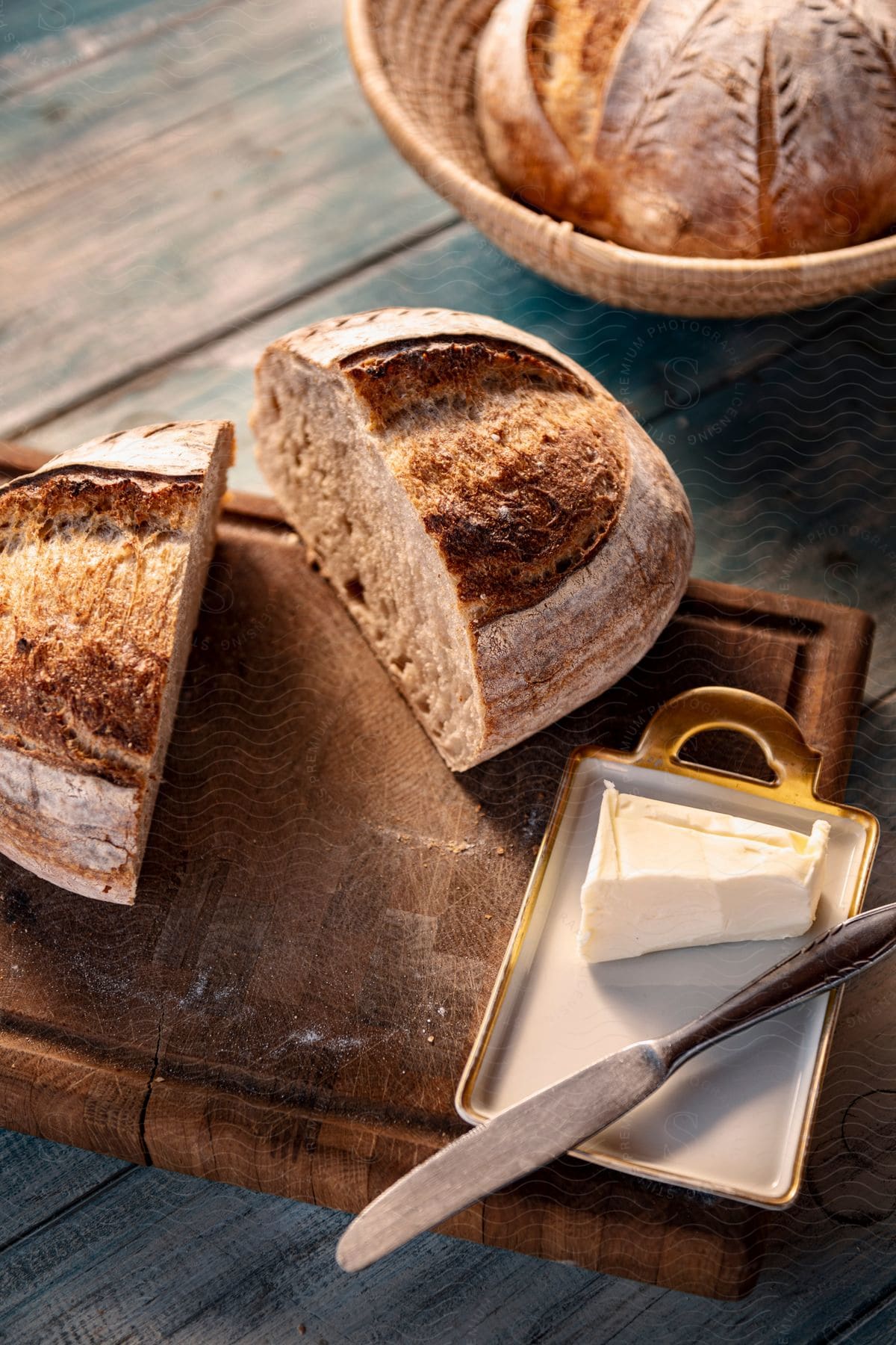 Table with whole grain bread on a wooden table and with a slice of butter with a knife next to it