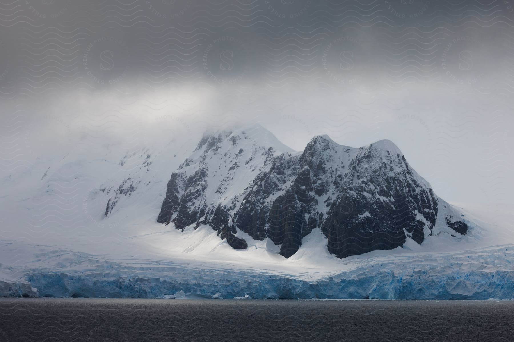 Snowy mountains rising out of a coastal glacier.