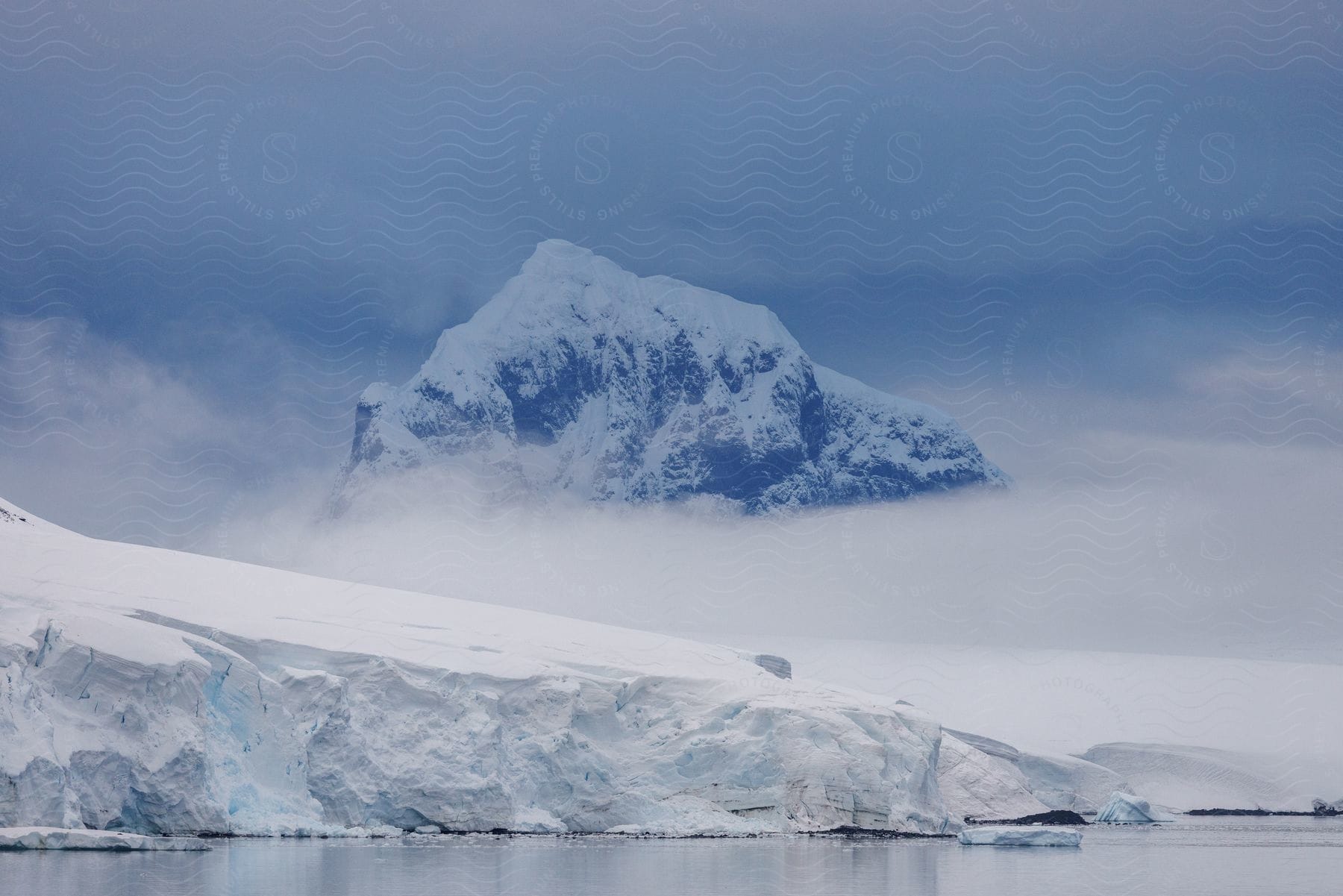 Arctic natural landscape with icebergs and a snow-covered mountain in the background