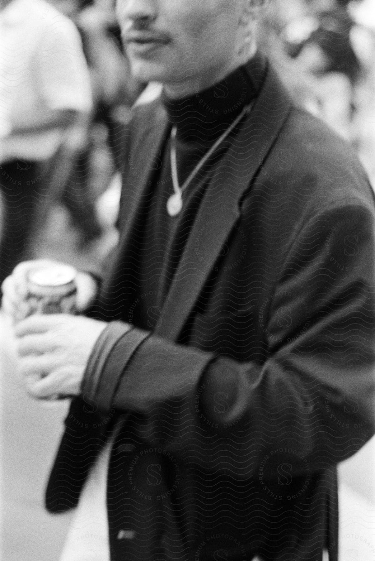 Man in black suit holding a drink