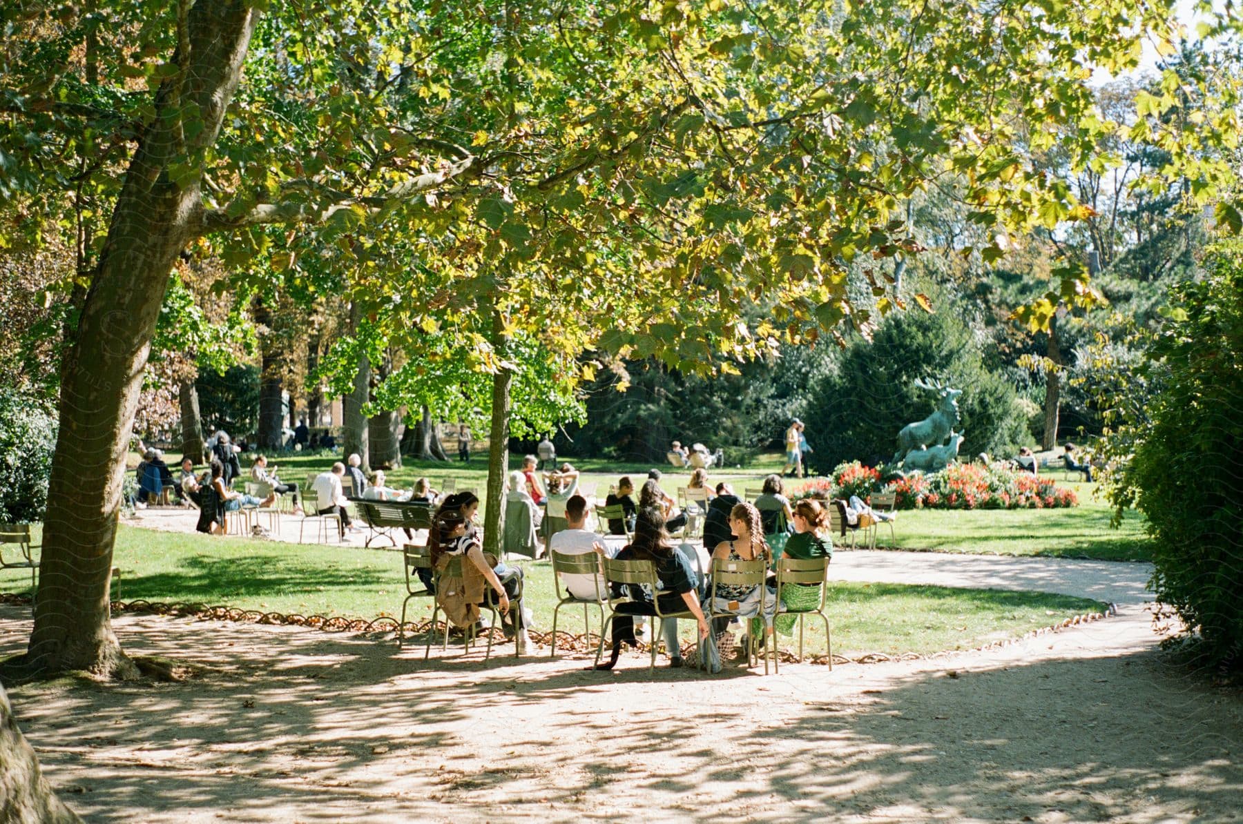 A group of people all sitting outdoors at a park