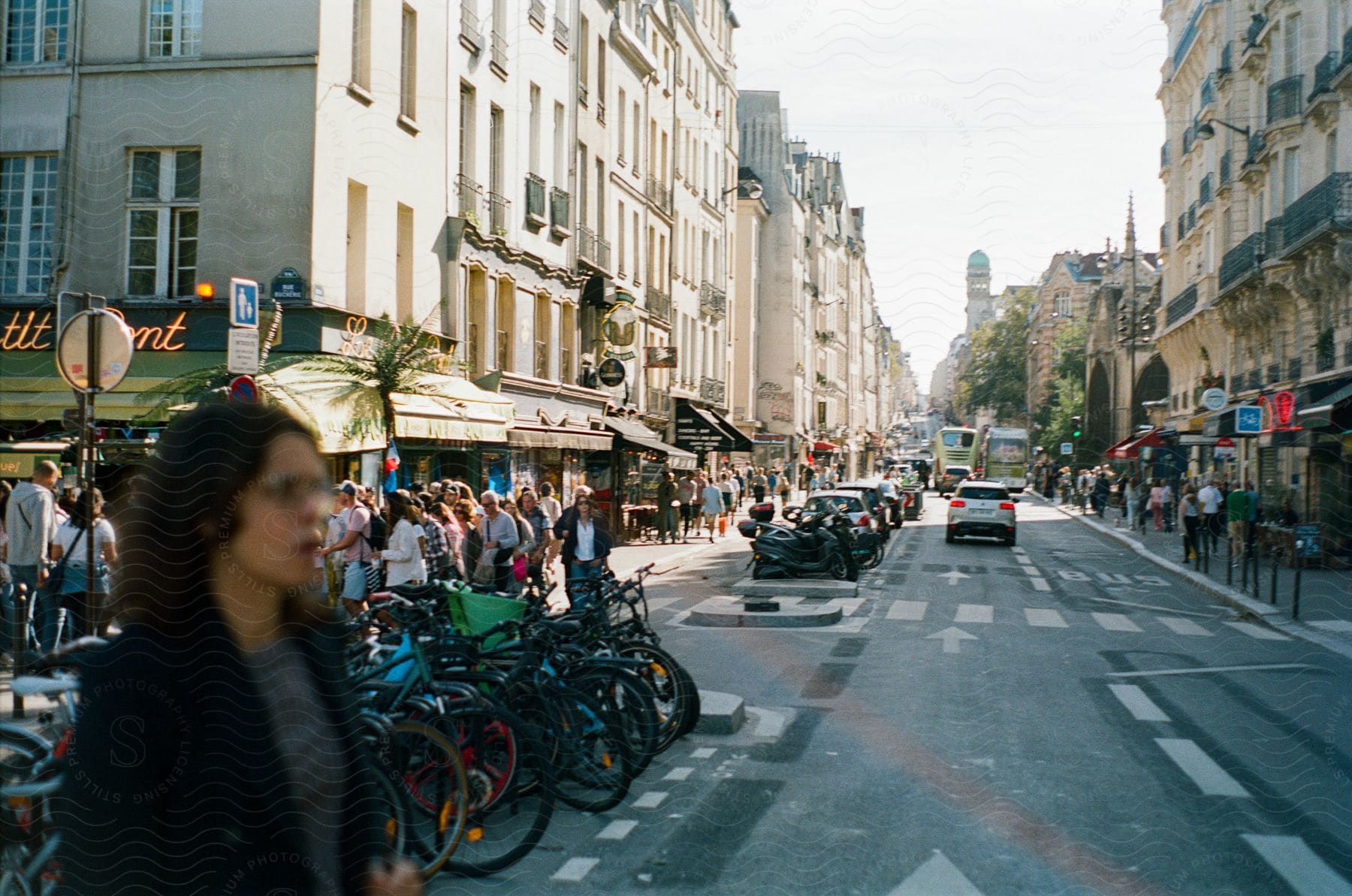 Street of a busy metropolis with pedestrian vehicles and parked bicycles