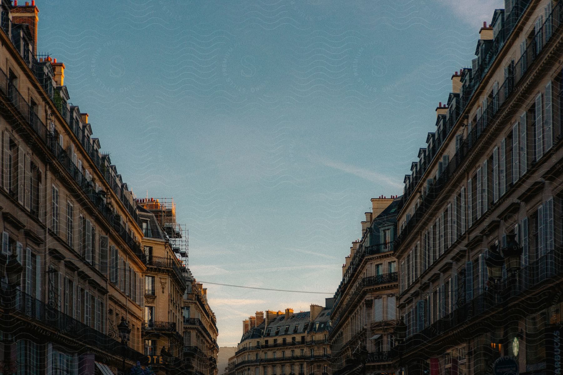 A street in Paris with classic Haussmann-style buildings during sunset