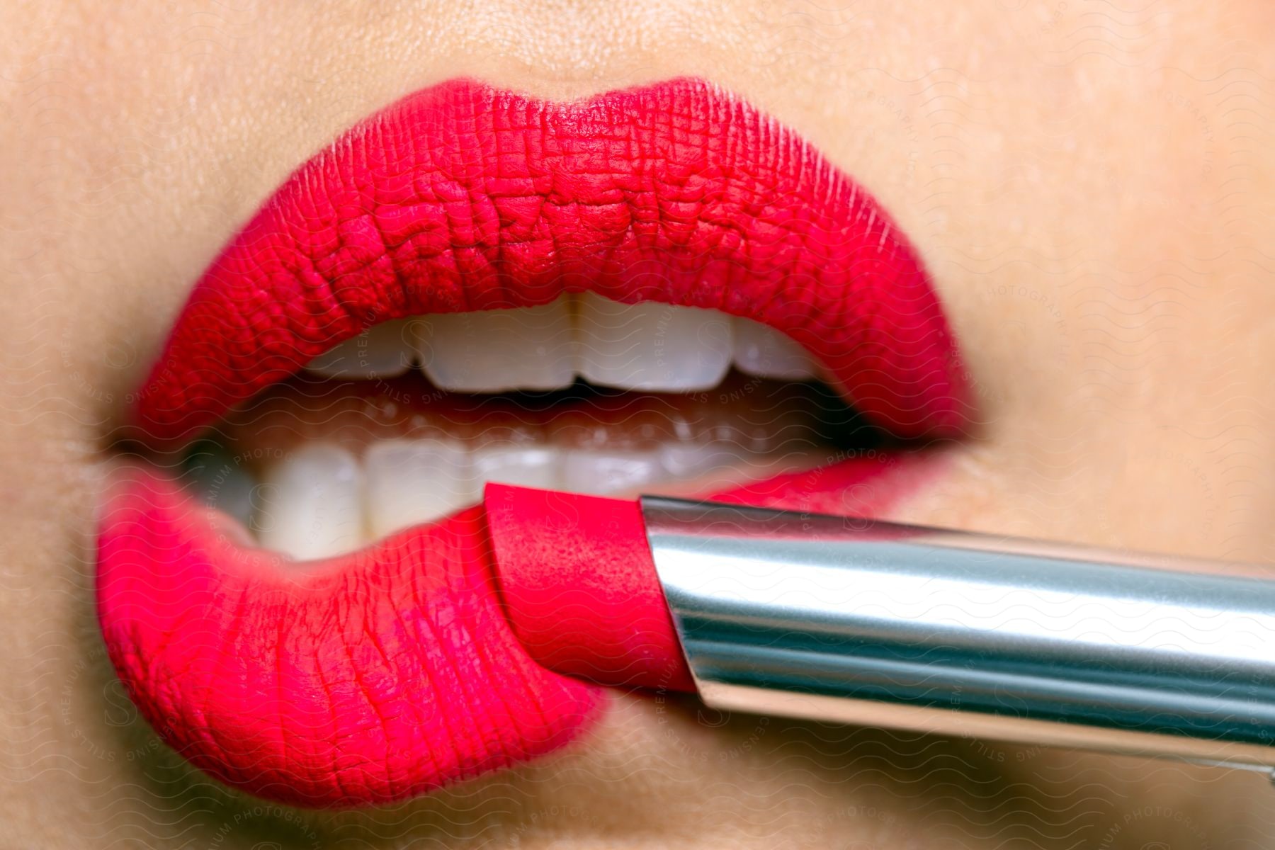 Red lipstick being applied to a woman's lips