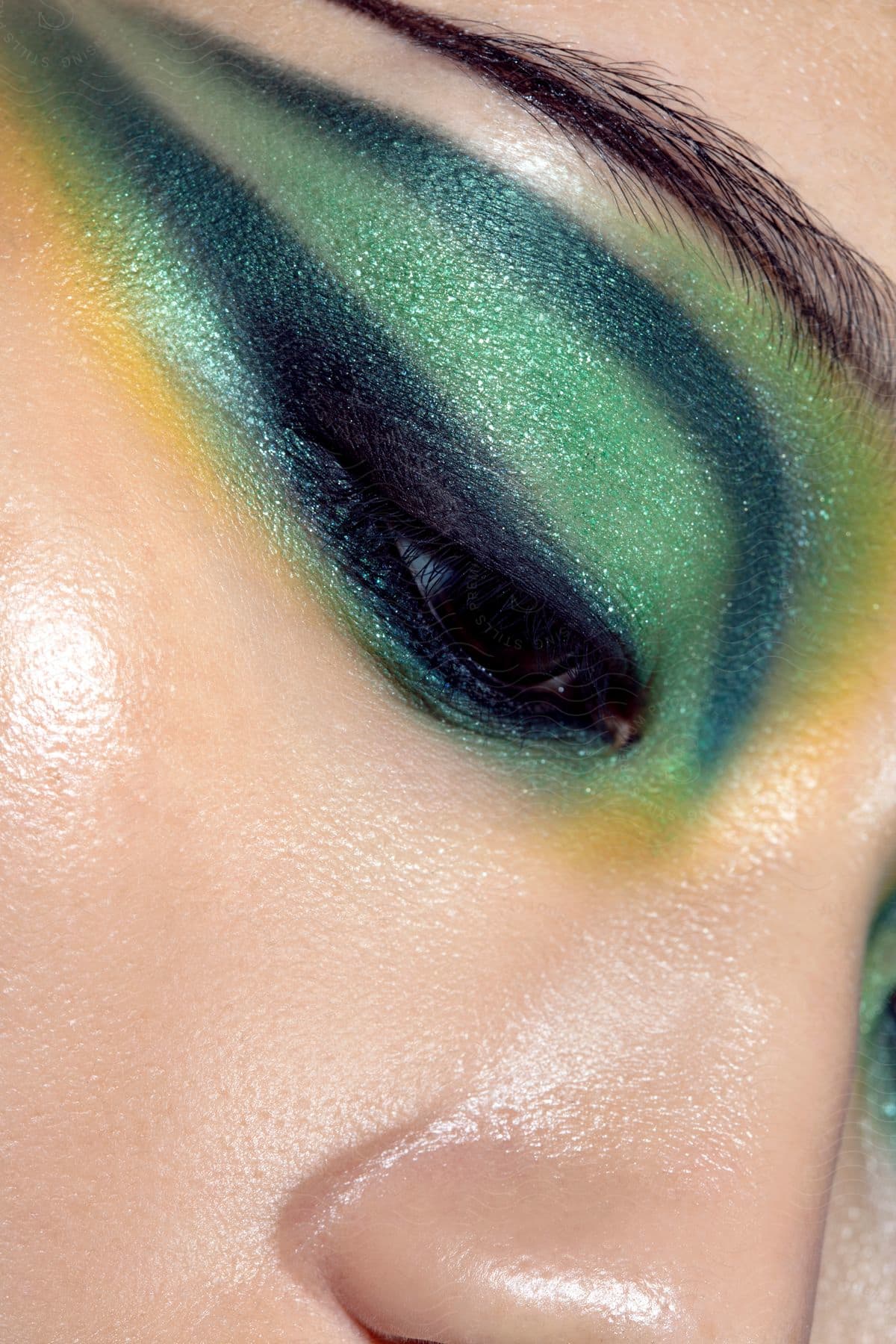 Woman wearing shiny green eyeshadow across her eyelid