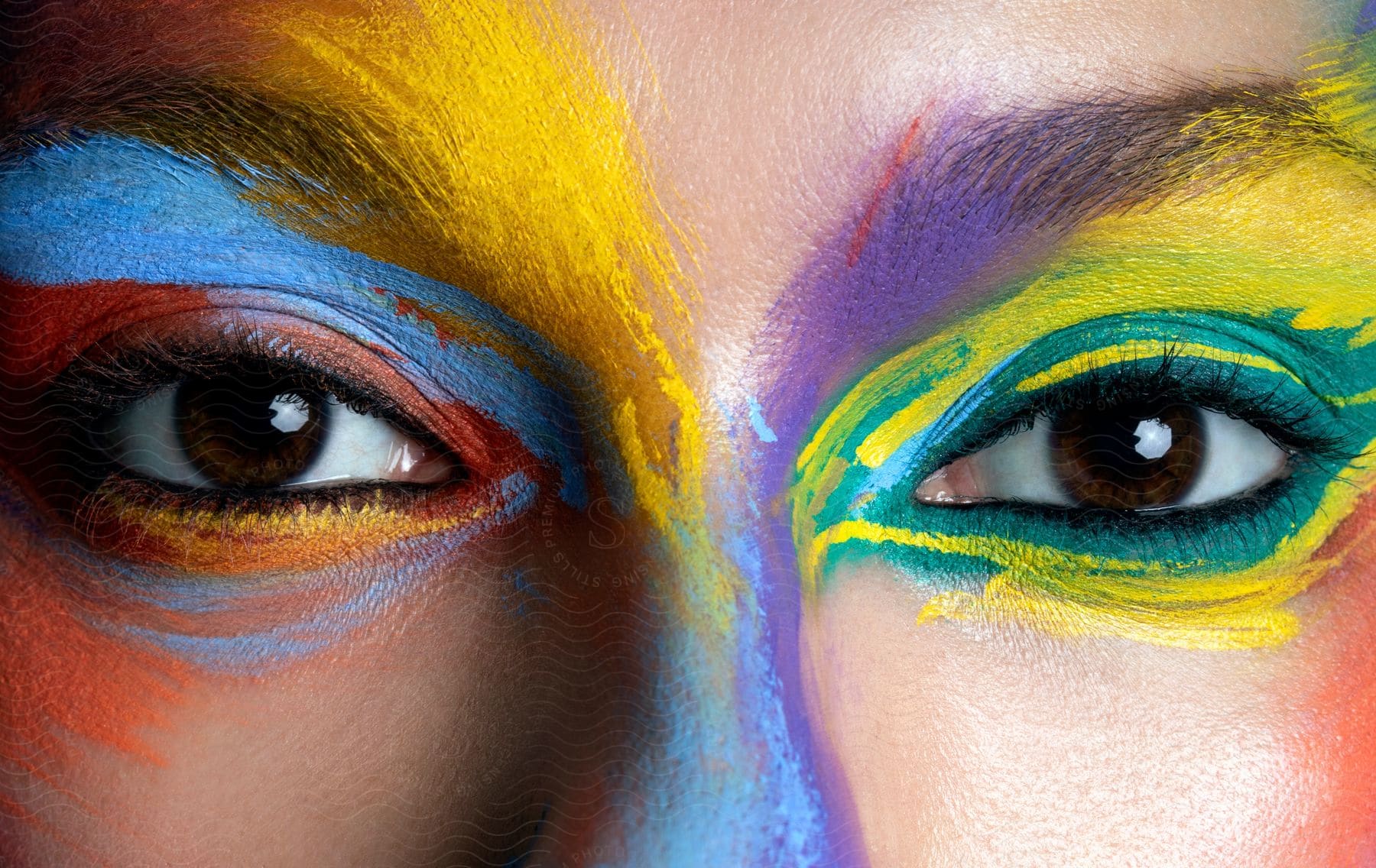 Close-up of a person's eyes, adorned with vibrant, multicolored make-up.