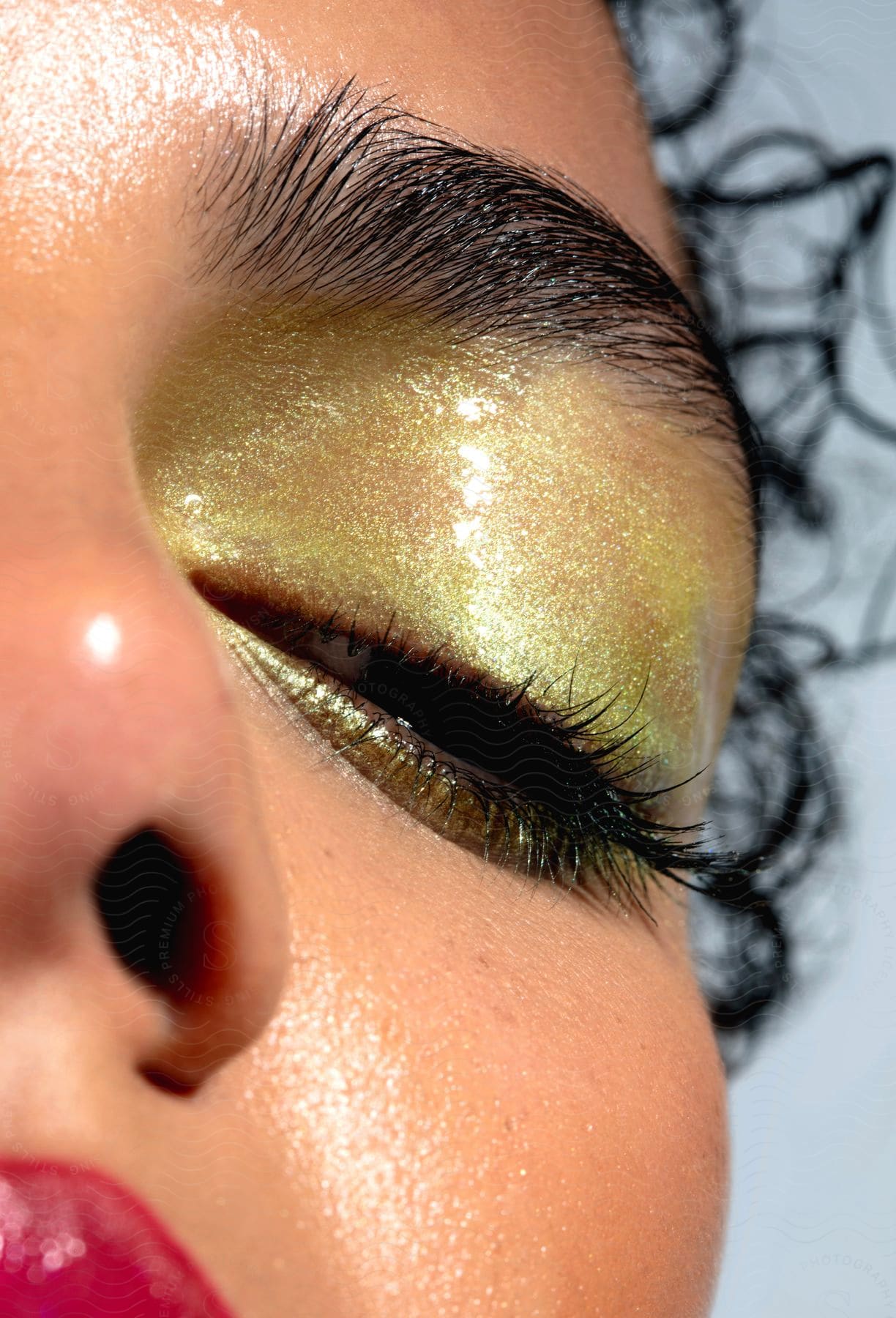 A woman with golden eyeshadow and red lips