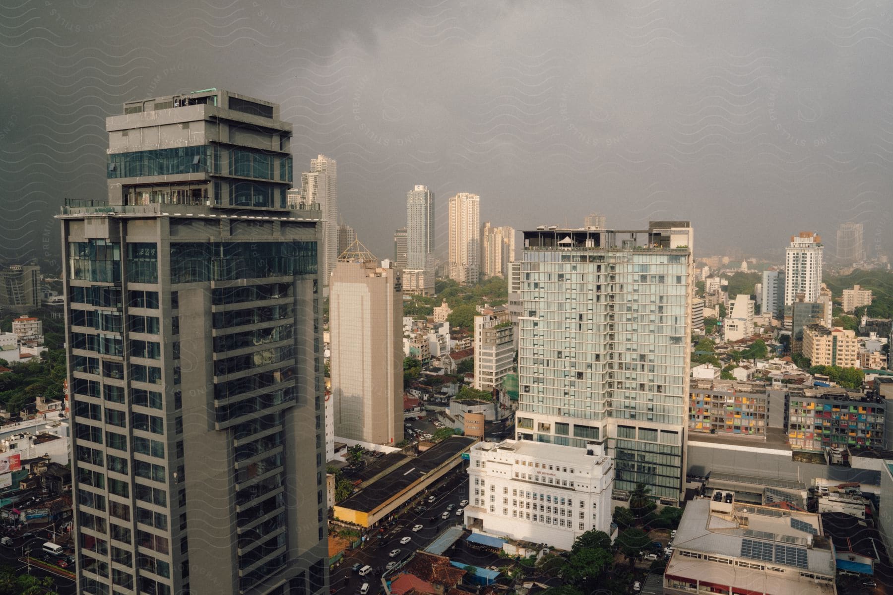 A cityscape featuring tall buildings with bustling highways filled with vehicles below.