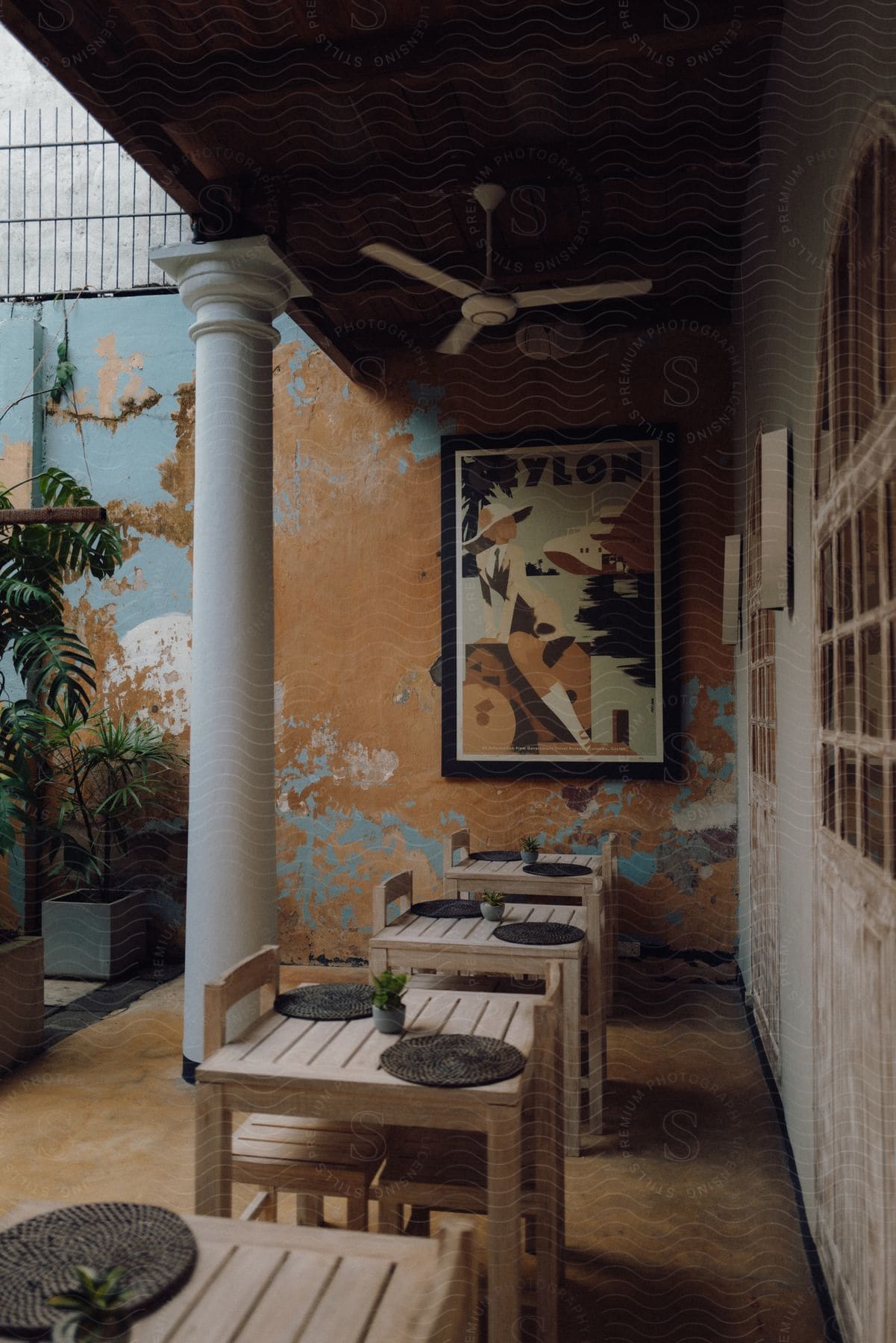 Interior architecture of rustic wooden tables in an artistic frame on the worn wall in the background