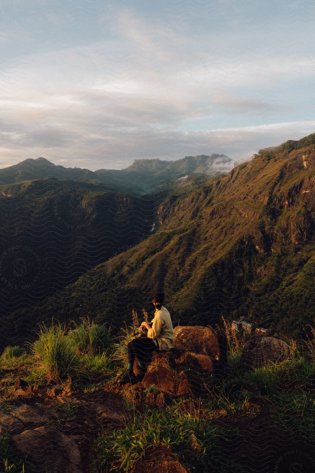 Person sitting on a rock enjoying a mountainous view