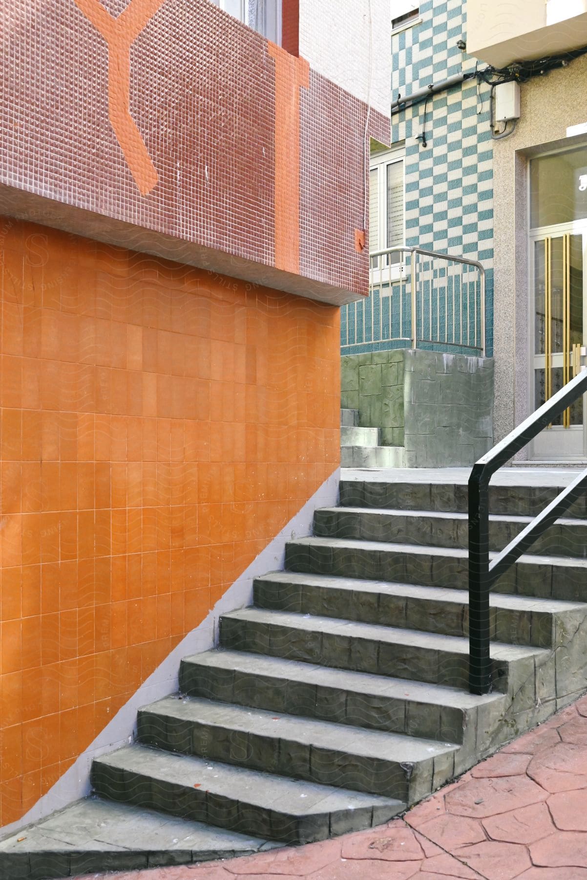 A concrete staircase with seven steps and a black metal handrail on the right for support.