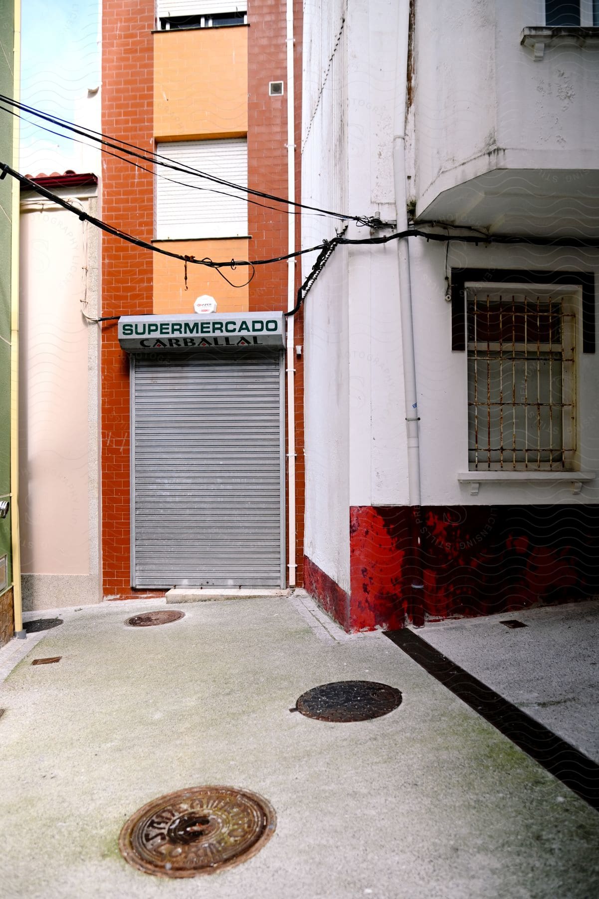 Narrow alley between two buildings with a supermarket called Carballal.