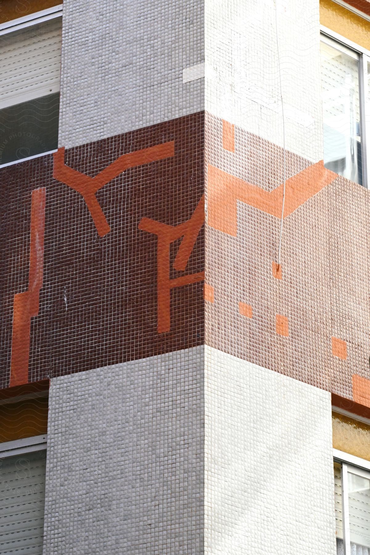 Abstract mosaic design on an urban building facade.