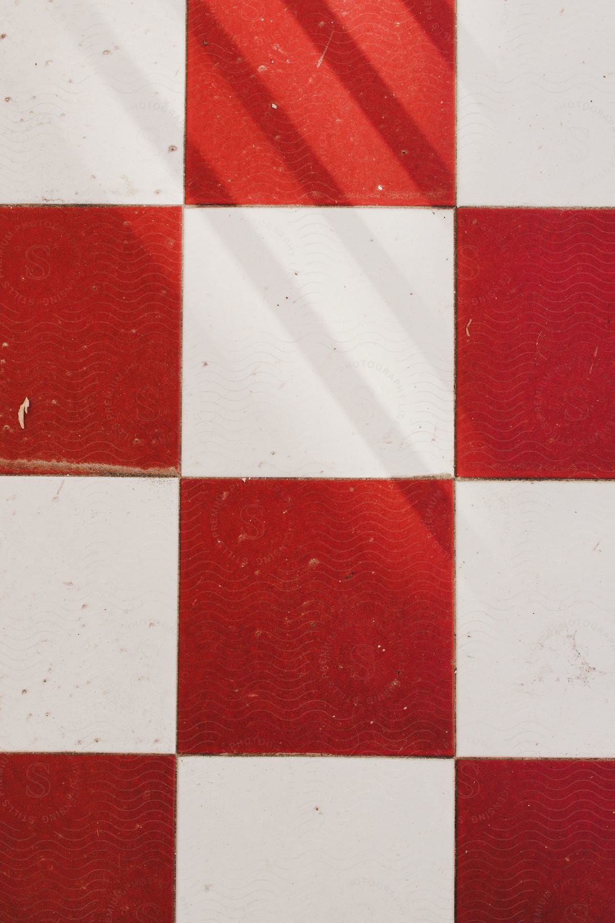 A white floor with red squared carpet swatches laid out in a checkerboard pattern