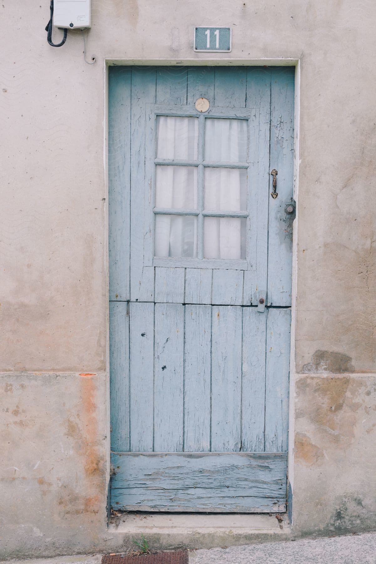 Light blue wooden door with the number eleven on top