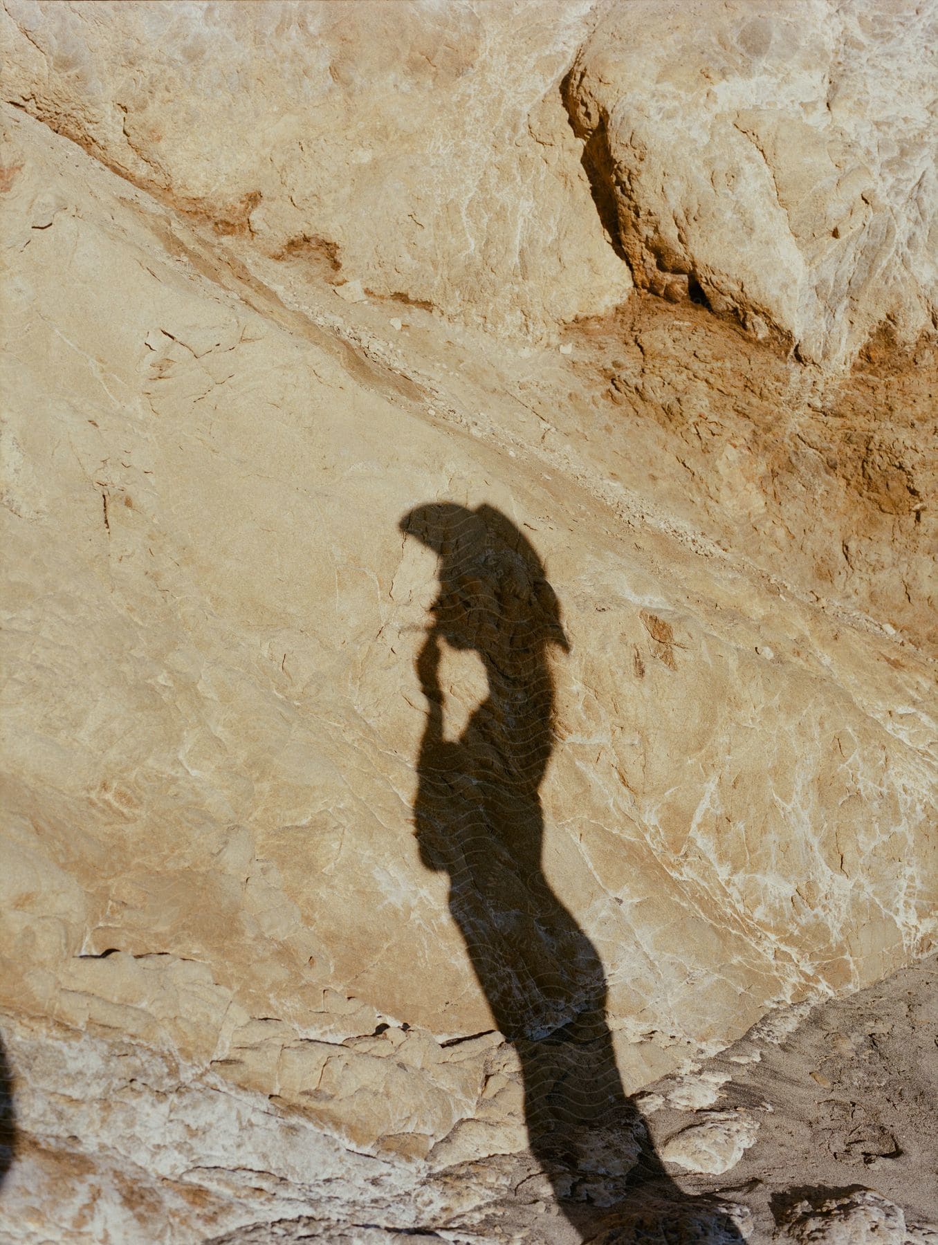 A shadow of a woman smoking outdoors