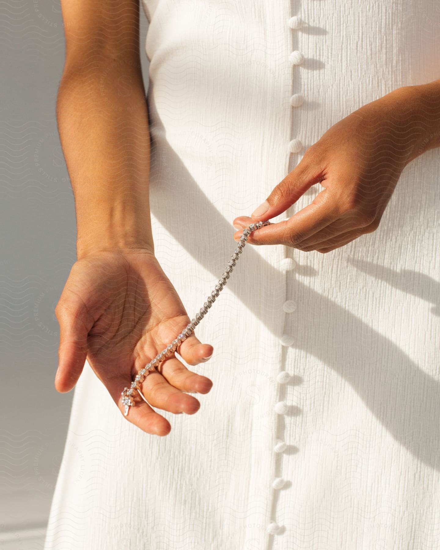 Woman's hands holding a necklace of precious stones.