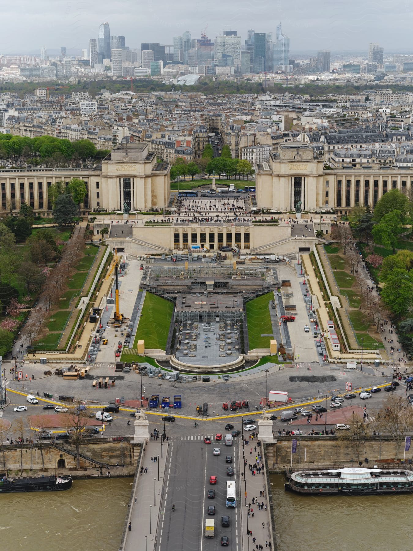 A large city with many people walking around and many streets, the city is on a river front.