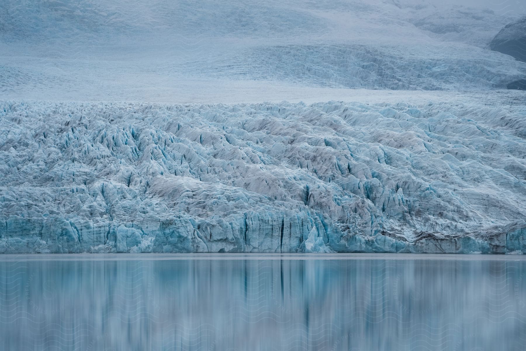 Arctic ice along the coast reflects on the water