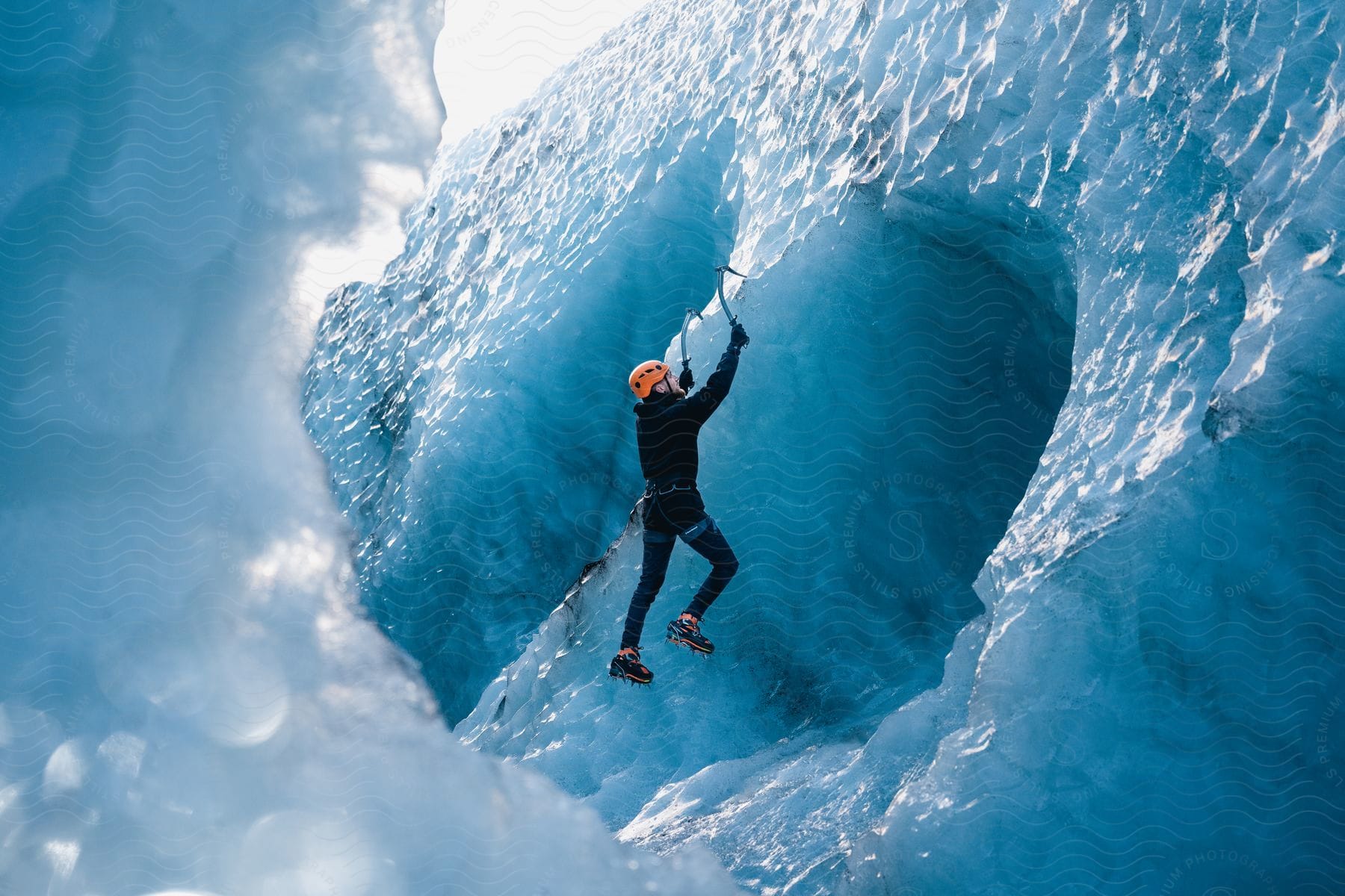 A man uses hooks to climb ice