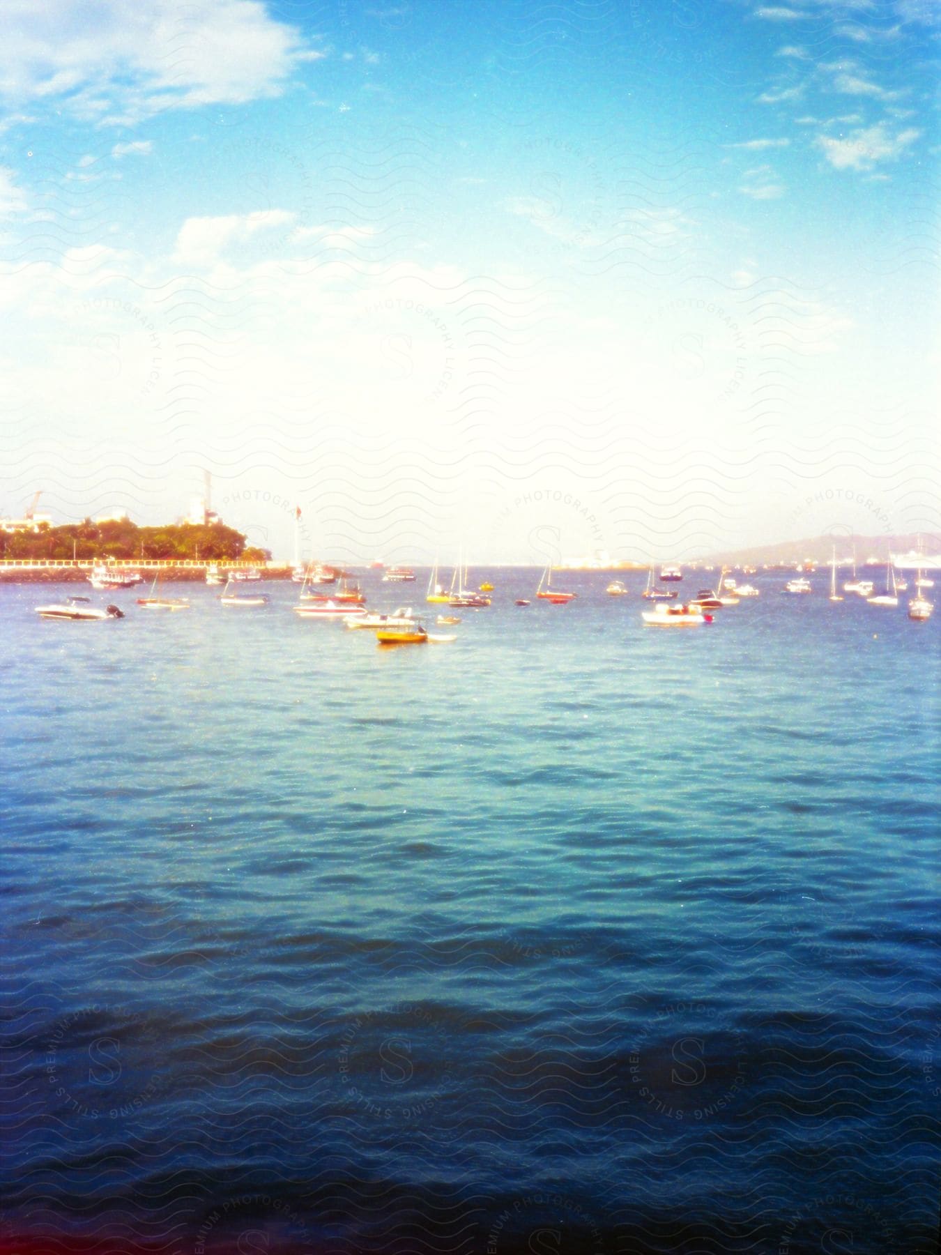 A serene view of boats floating on blue water under a clear sky.