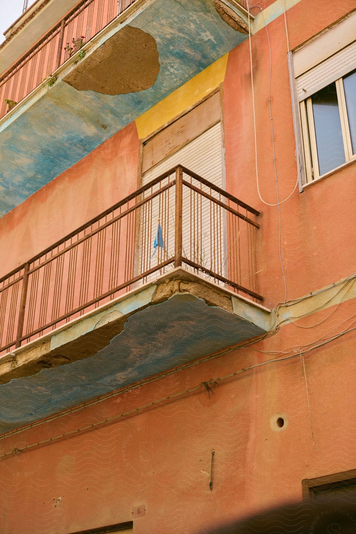 Orange apartment building with dilapidating balconies