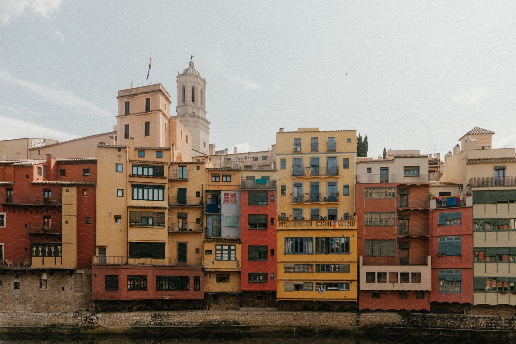 A series of colorful buildings lined up along the bank of a river. The buildings are brightly colored, including shades of yellow, red, orange and green.