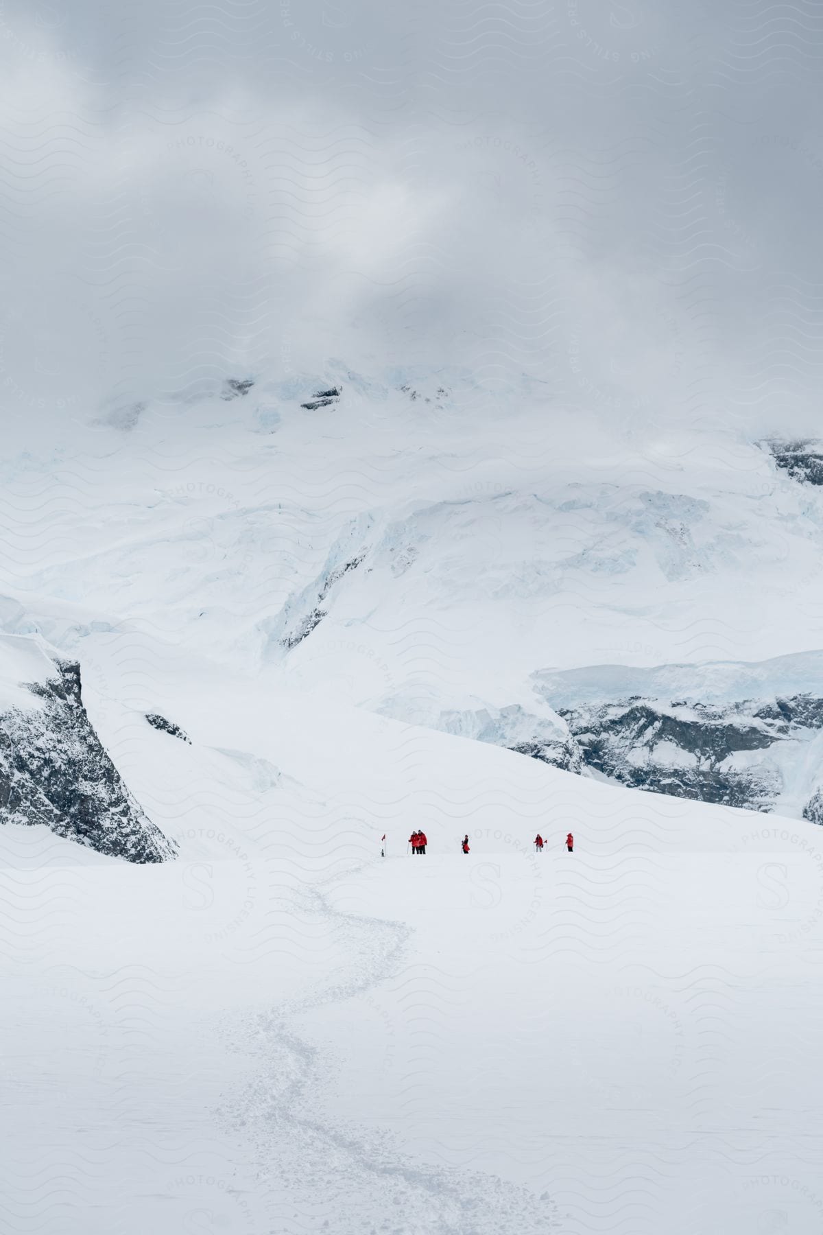 Mountain landscape covered by snow on a cloudy day and people walking