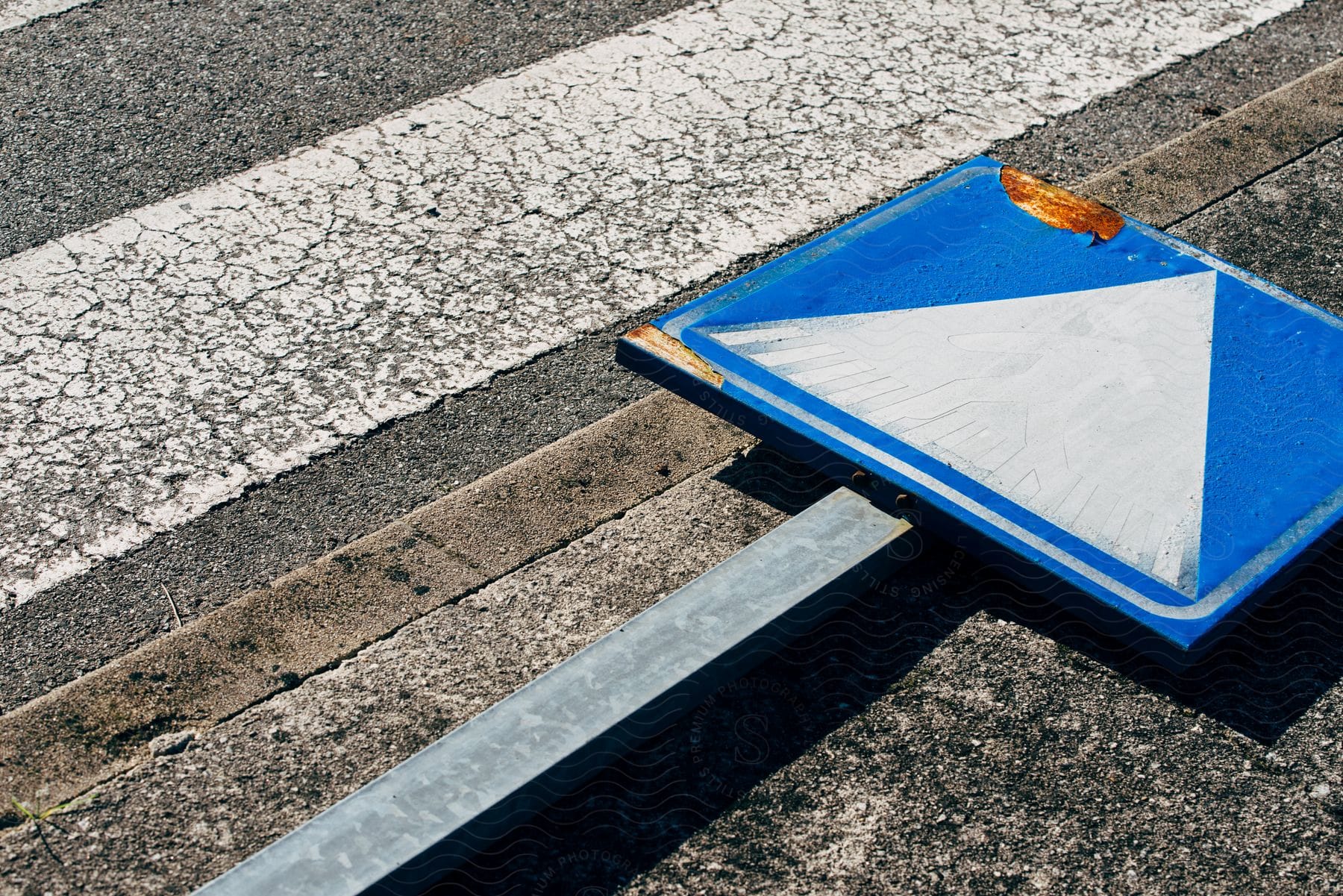 A view of a sign that is laying on the ground in a city