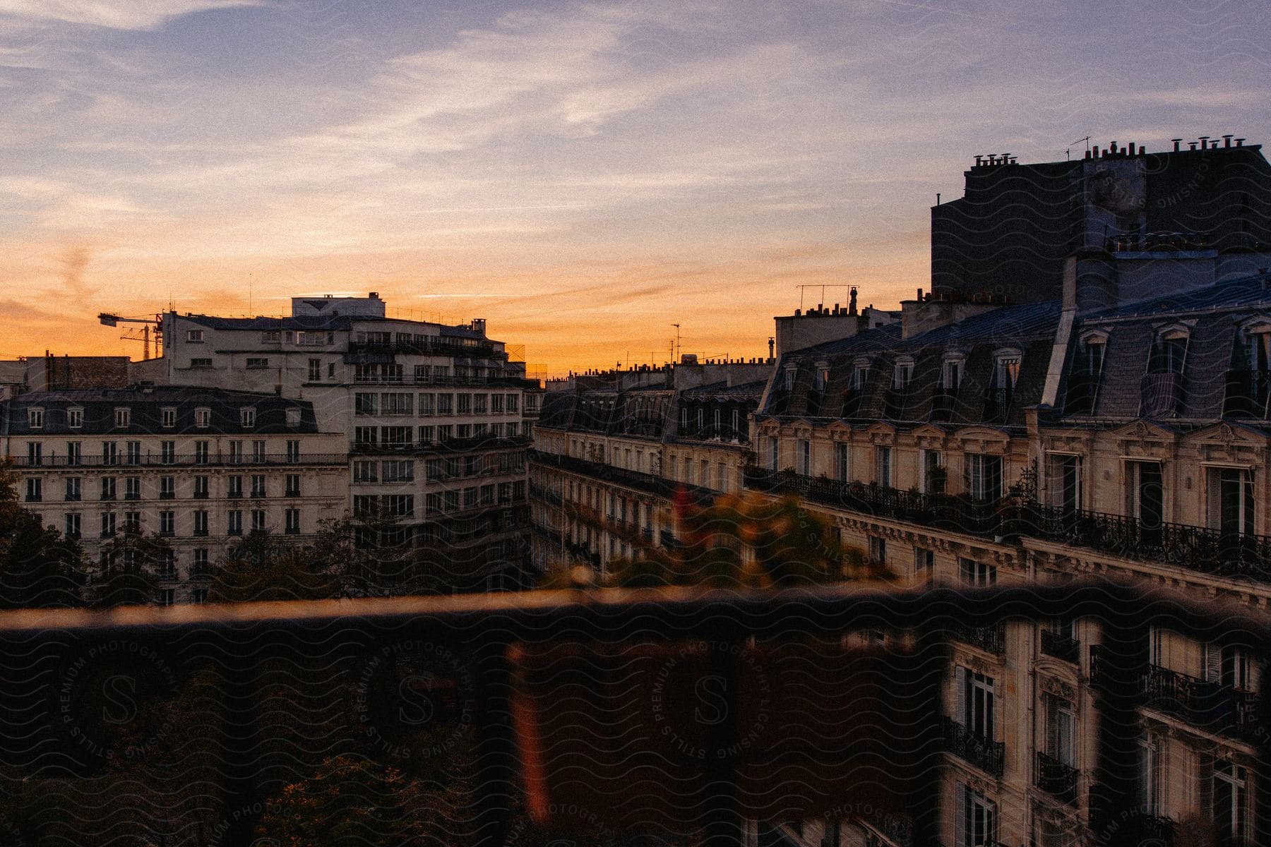 Older appearing white buildings that are close together at dusk.