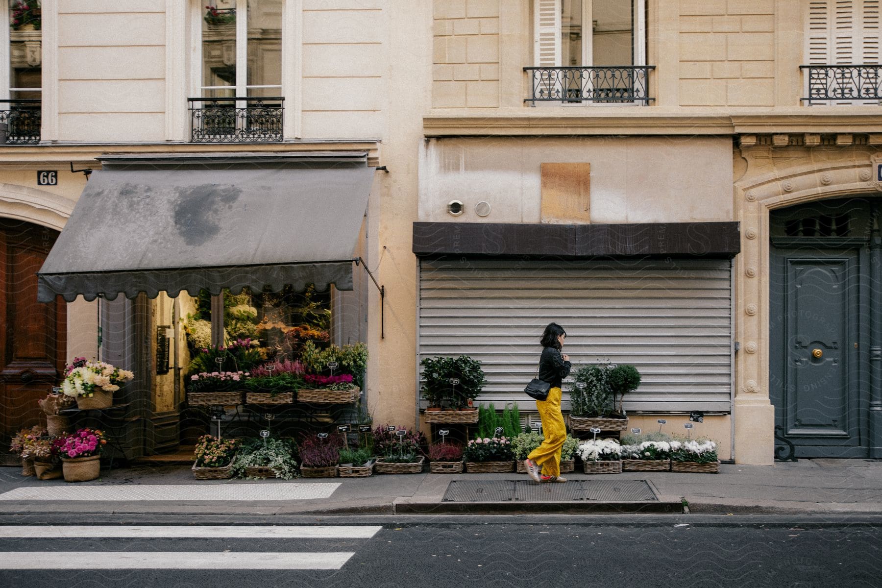 A woman walking down a sidewalk in a city