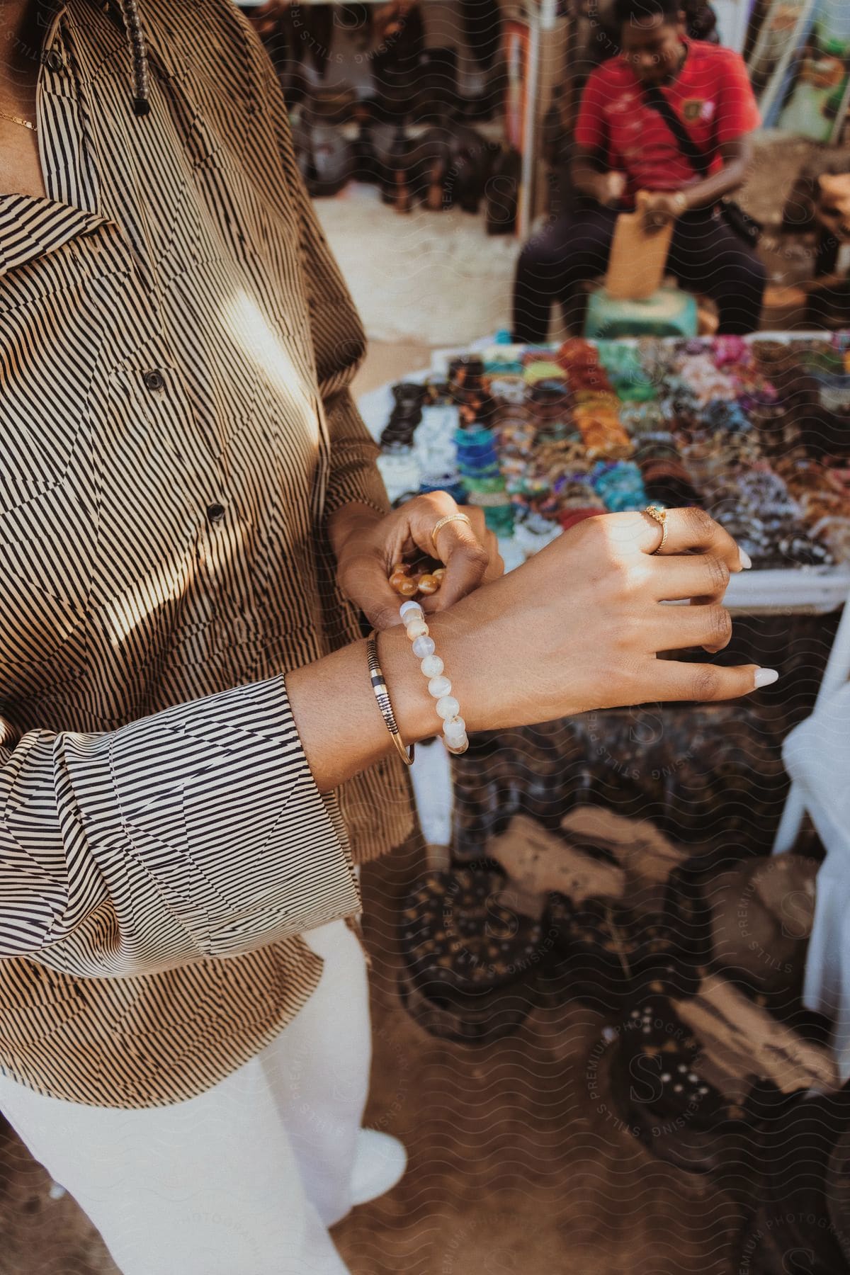 A person examining jewelry at an open-air fair.