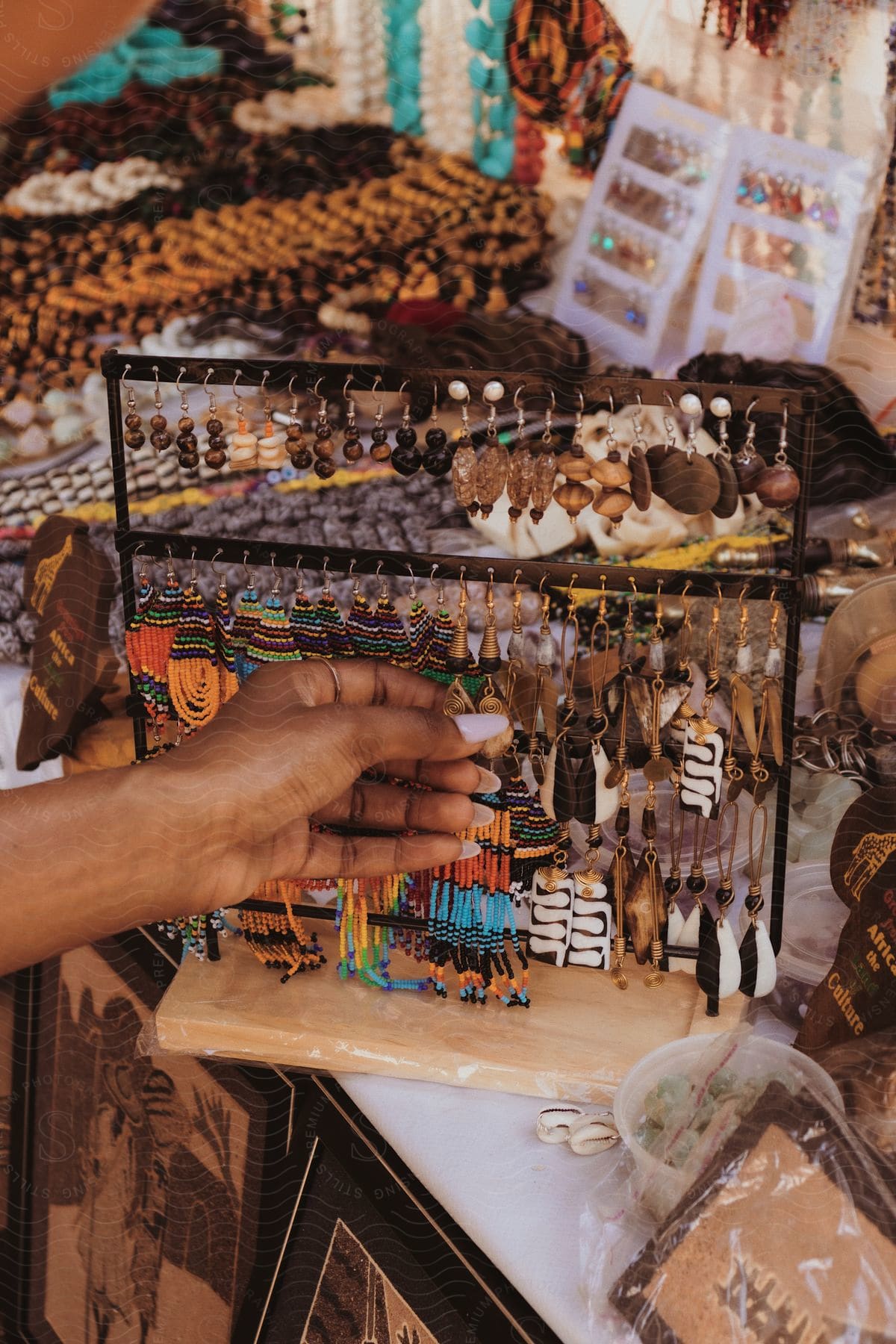 A person's hand touching Native American style jewelry at a store