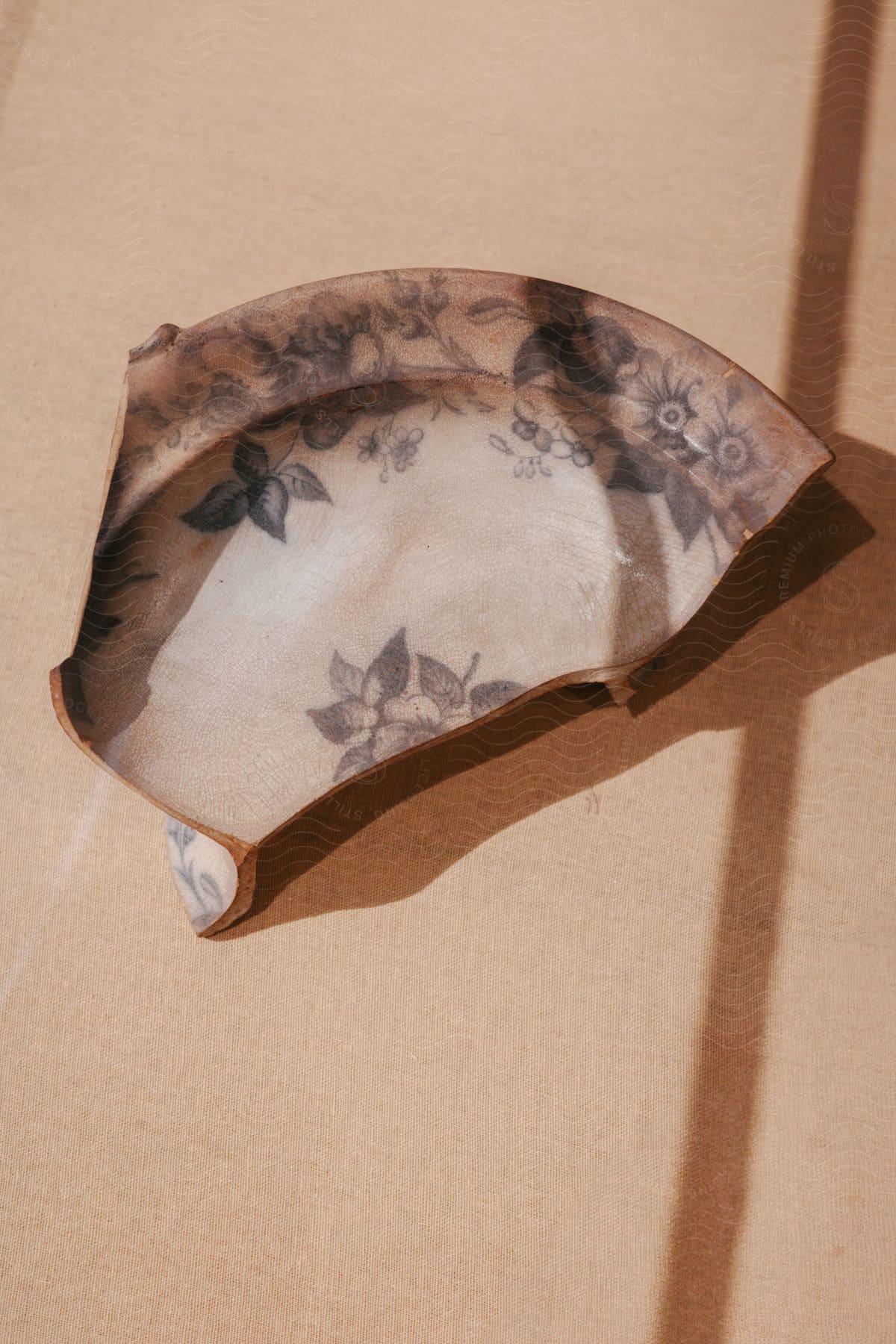 A broken ancient plate sitting on a table as decor