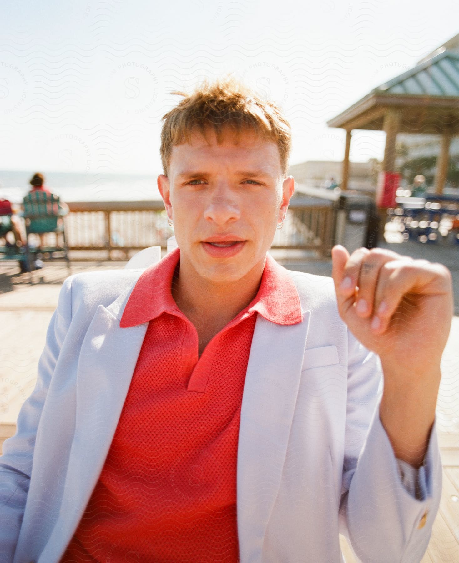 Man holding his arm up as he looks into the camera