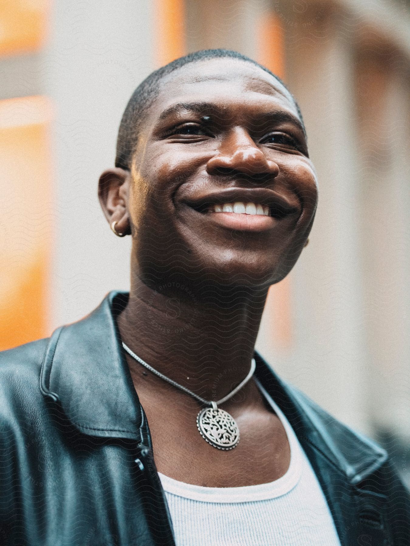 Portrait of a man in a smiling leather jacket and a silver necklace