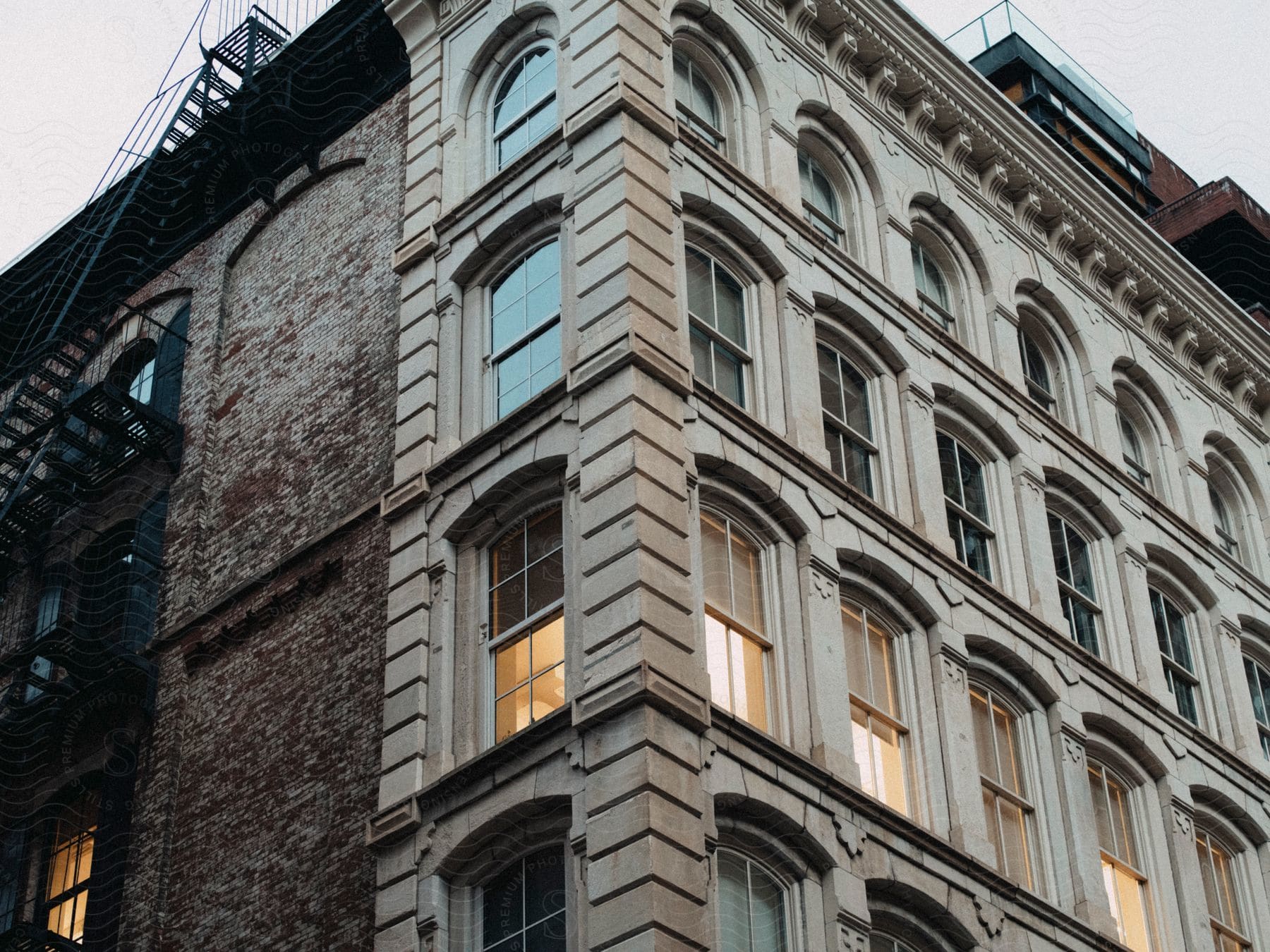 A towering apartment complex gleams with windows, a fire escape tracing its side